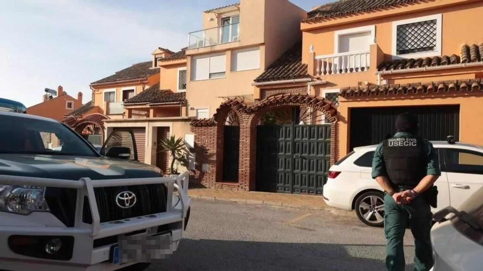 Un agente de la Usecic de la Guardia Civil custodiando la entrada a una de las viviendas registradas este martes. Un agente de la Usecic de la Guardia Civil custodiando la entrada a una de las viviendas registradas este martes.