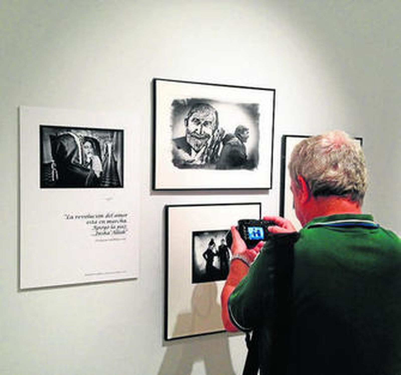 Un visitante fotografía una de las instántaneas con su móvil.