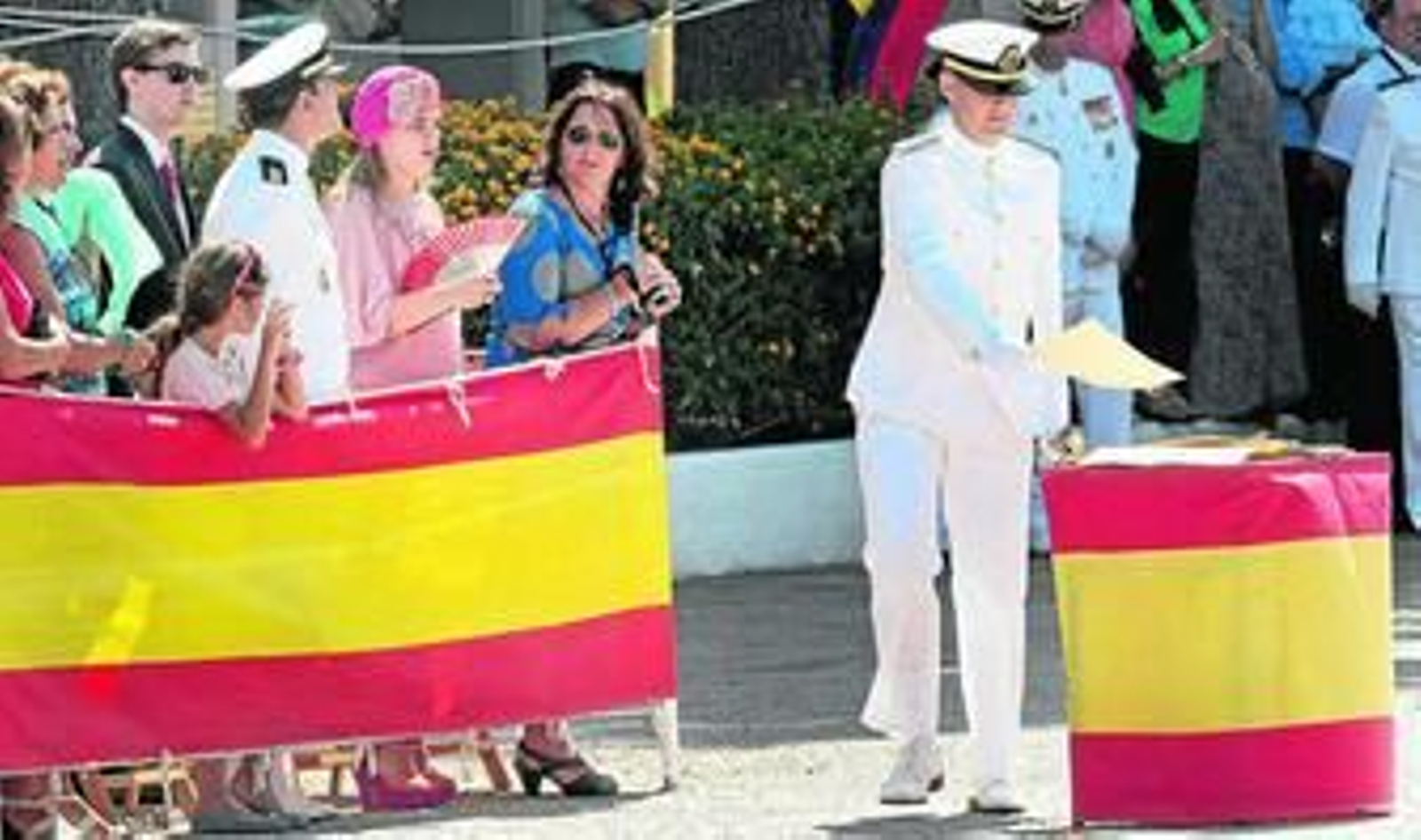Familiares con abanicos y cámaras de vídeo mientras uno de los sargentos coloca en la mesa su diploma.