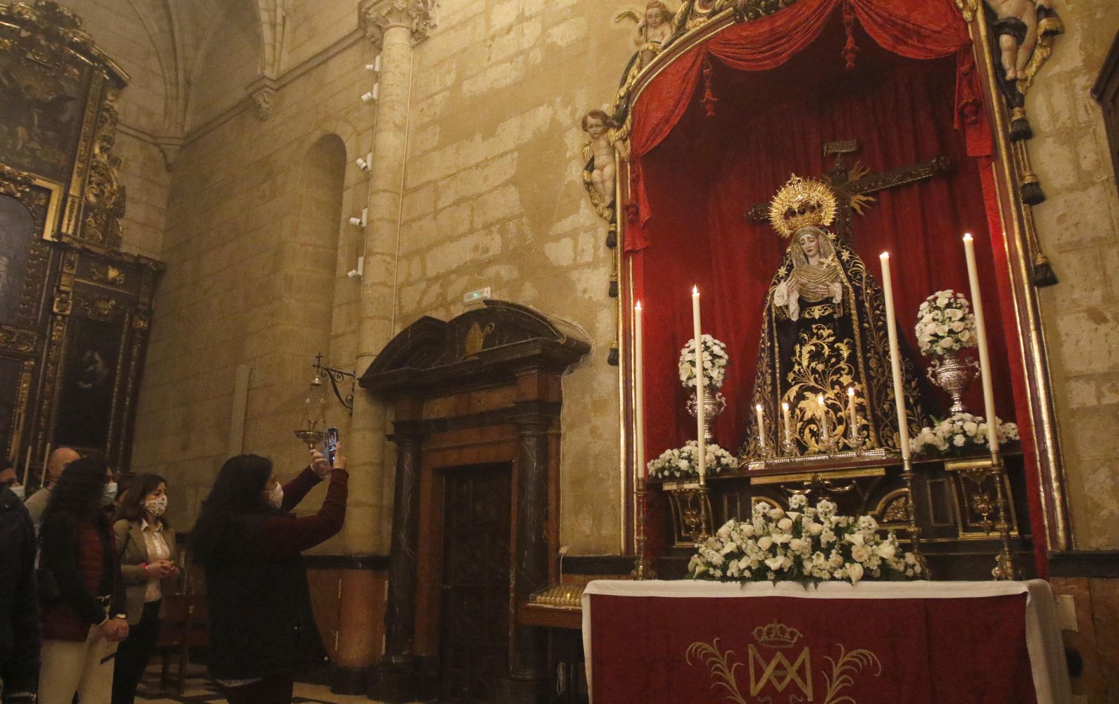 Varias personas fotografían a la Virgen de Gracia y Amparo.