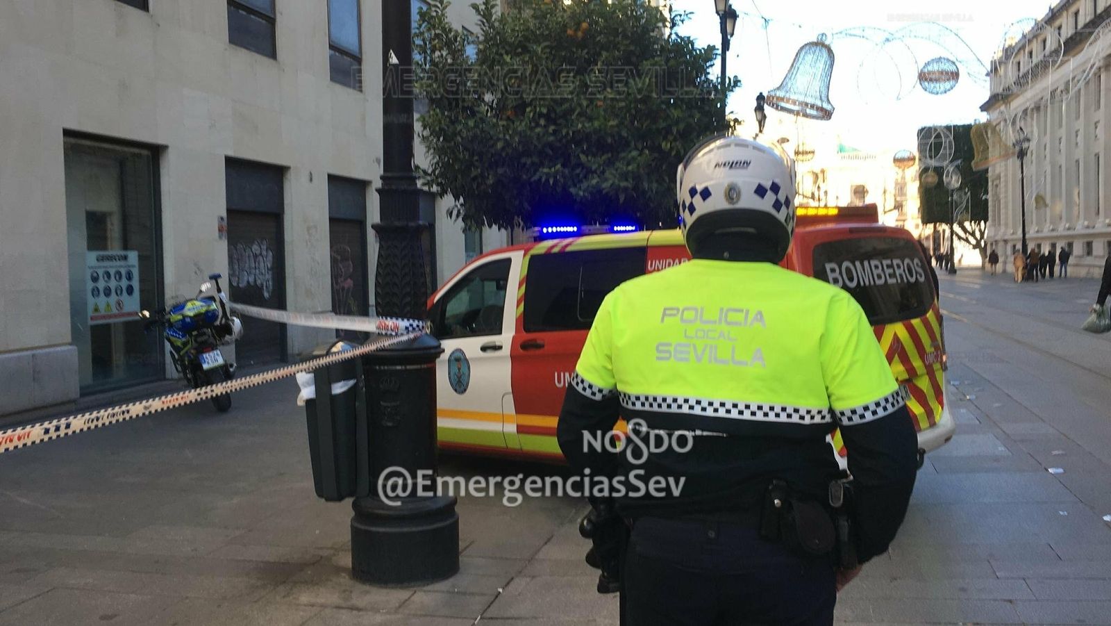 Un Policía Local junto a un coche de Bomberos en el lugar de los hechos.