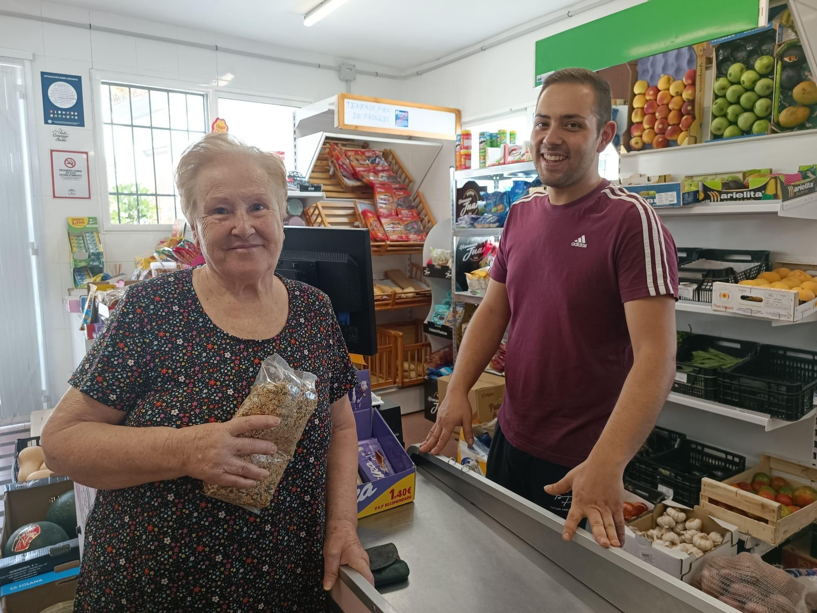 José Luis junto a una clienta en su tienda de Íllar.