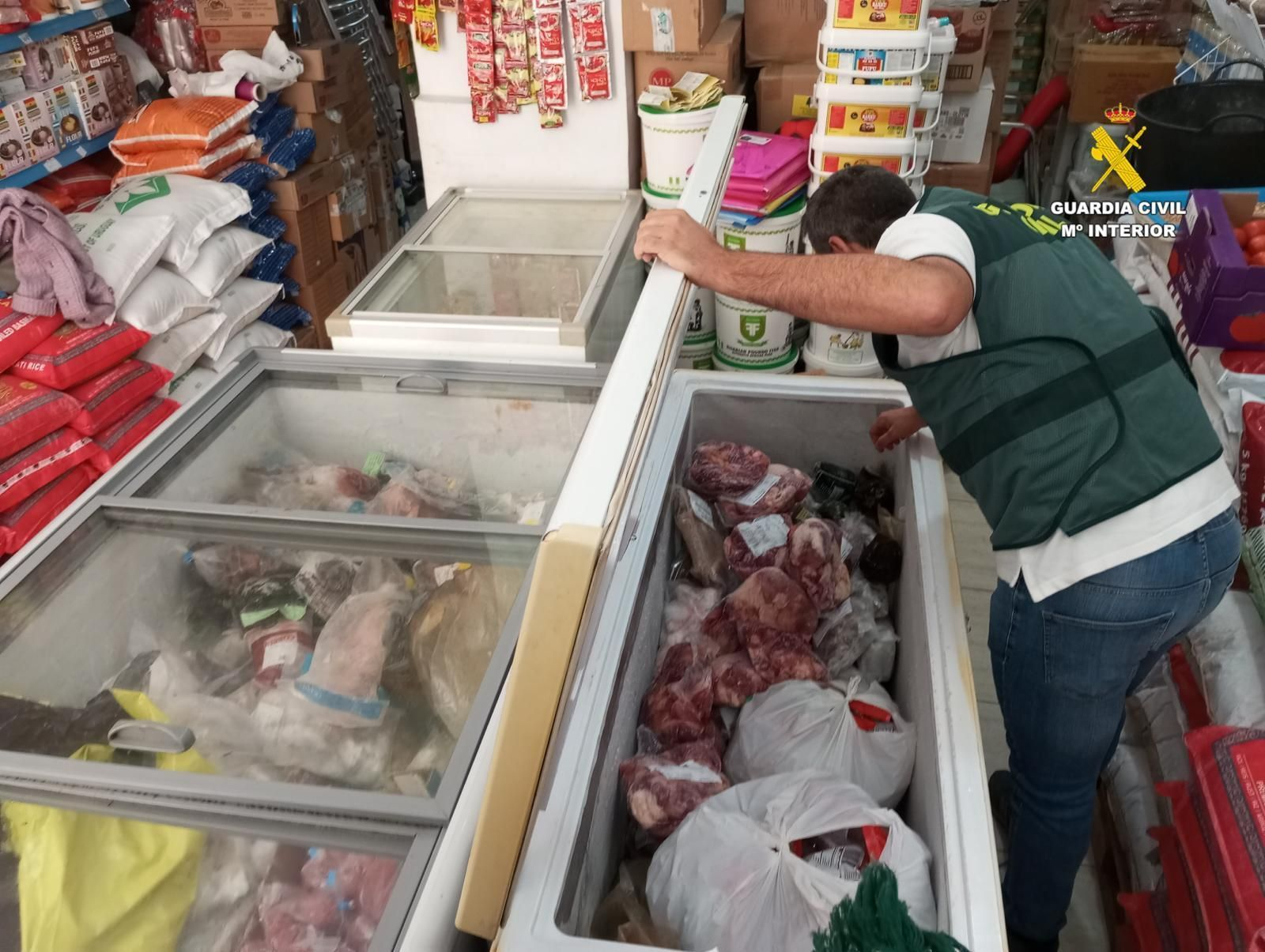 Uno de los guardias civiles inspecciona los congeladores de la tienda.
