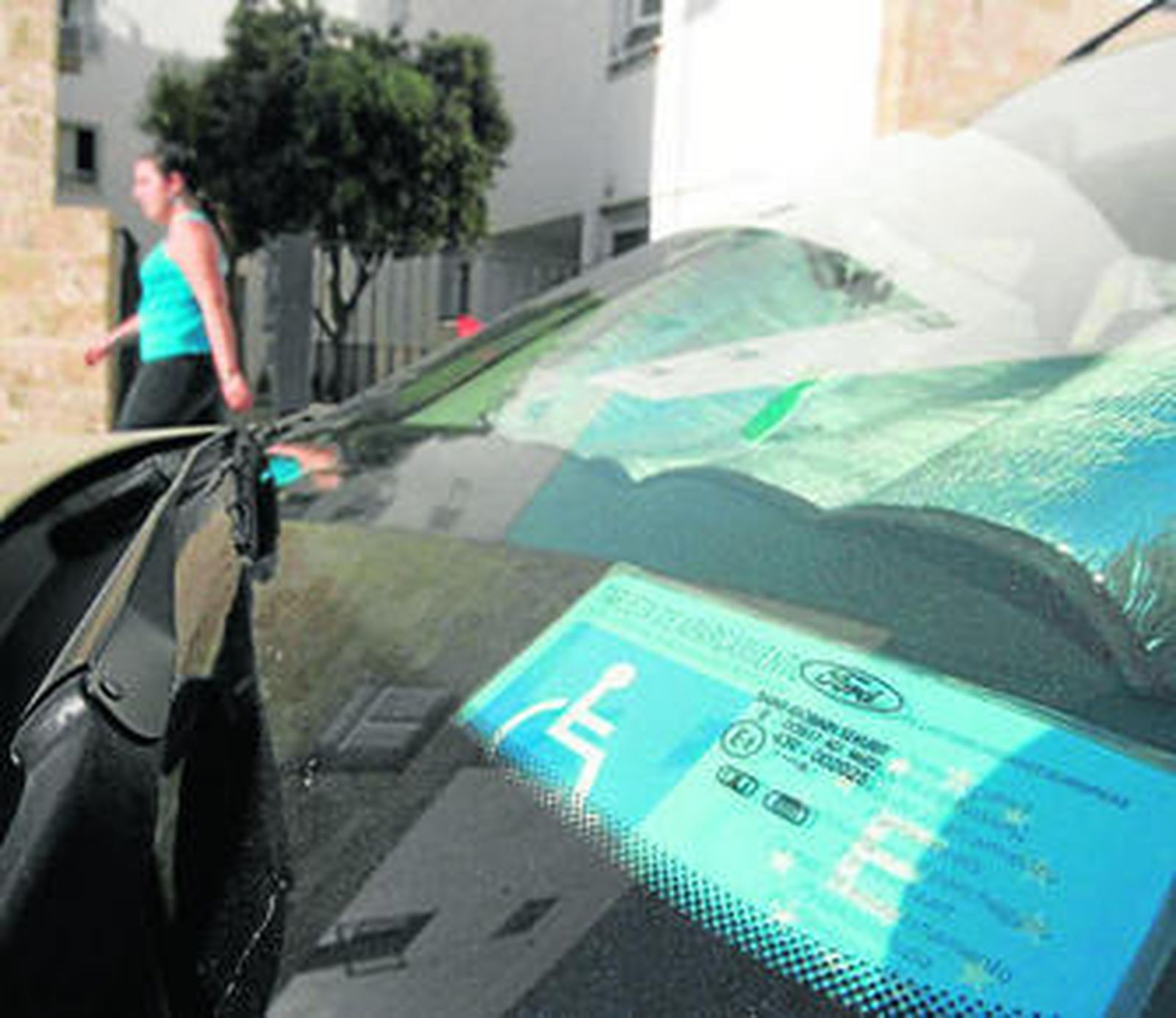 En el salpicadero del vehículo se muestra una tarjeta para el aparcamiento de personas de movilidad reducida.