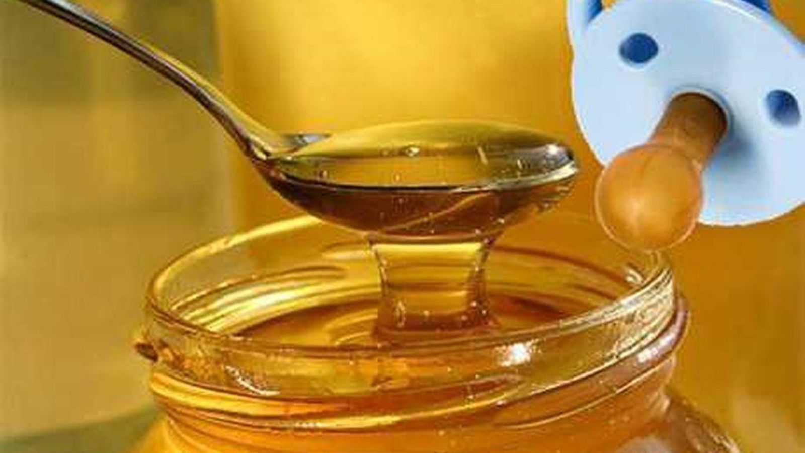 Un chupete a punto de ser mojado en miel.