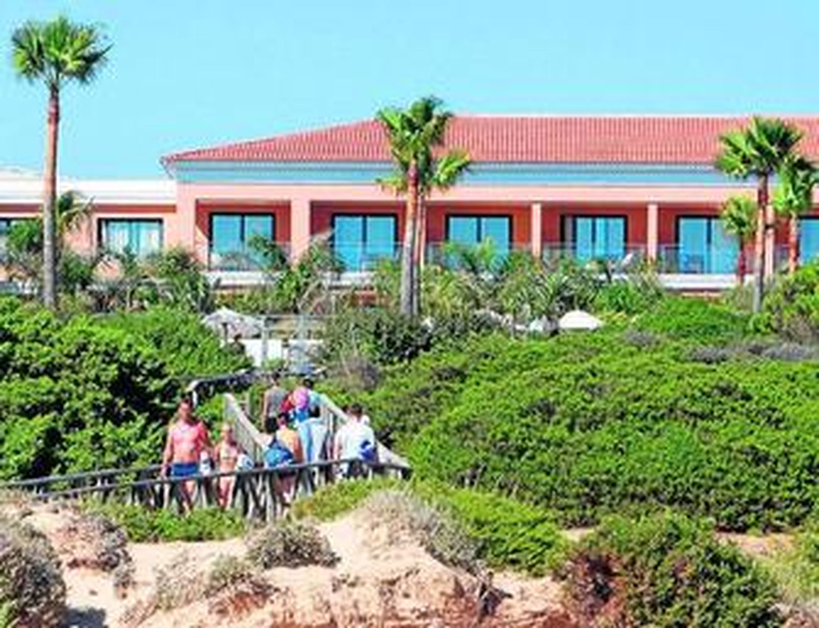 Turistas en la pasarela hacia la playa de uno de los hoteles de Chiclana, en una imagen del pasado verano.