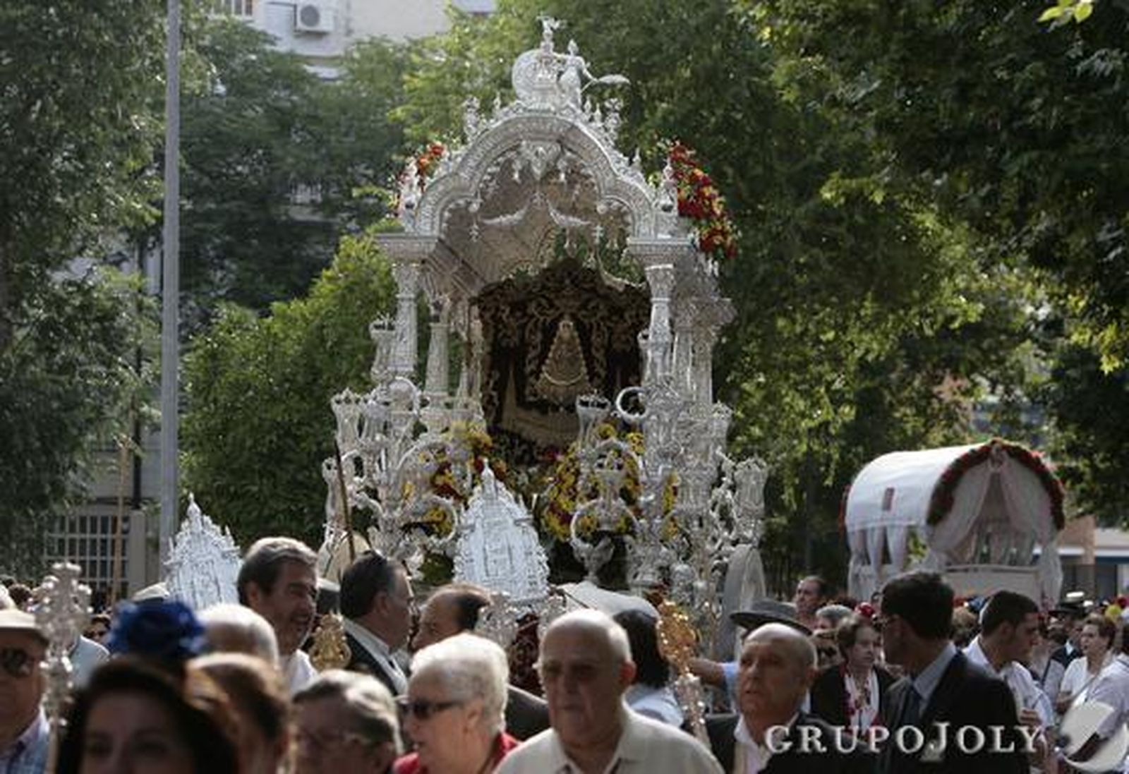 El simpecado de la Hermandad de Sevilla Sur, la primera de la capital en iniciar su peregrinaje, por las calles del del barrio.  Foto: José Ángel García