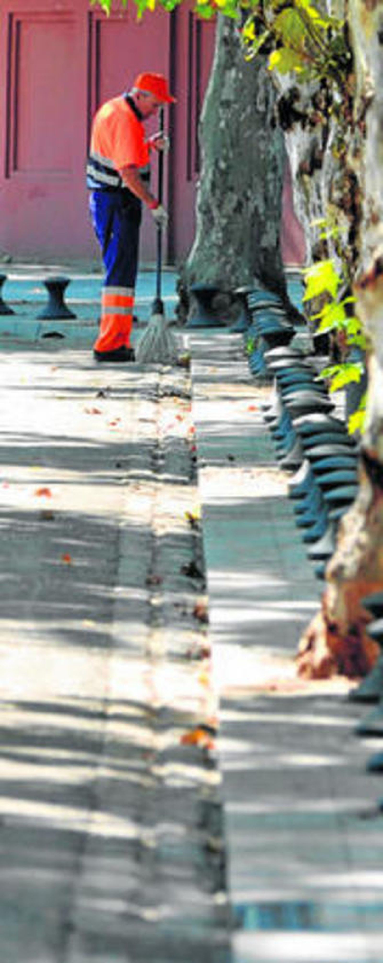 Un operario de Lipasam de faena en la calle Palos de la Frontera.