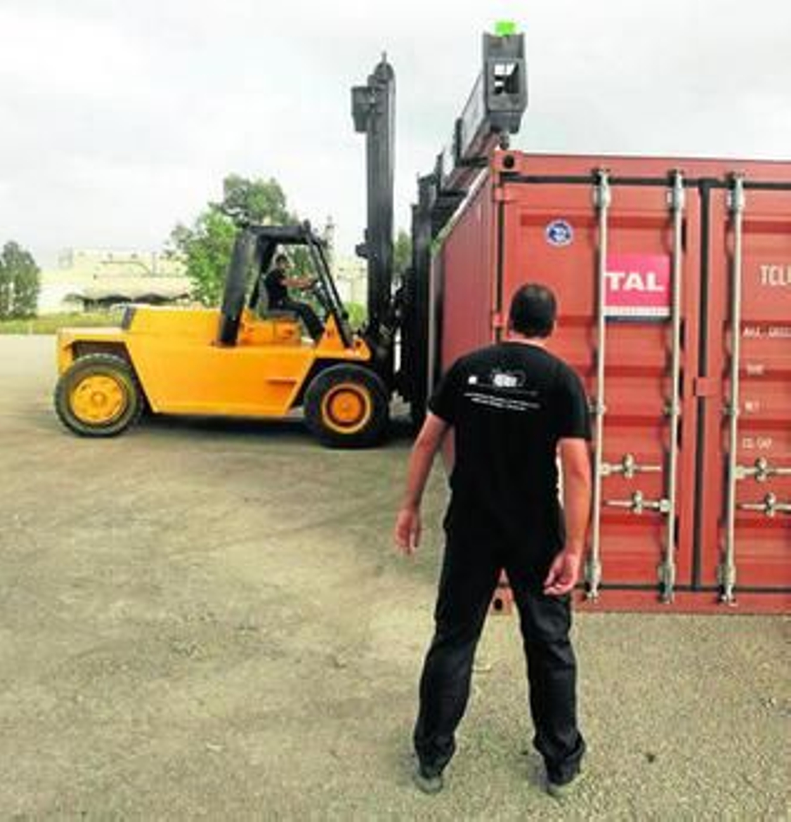 Dos operarios de SAM Algeciras mueven un contenedor, en la explanada anexa a Torraspapel.