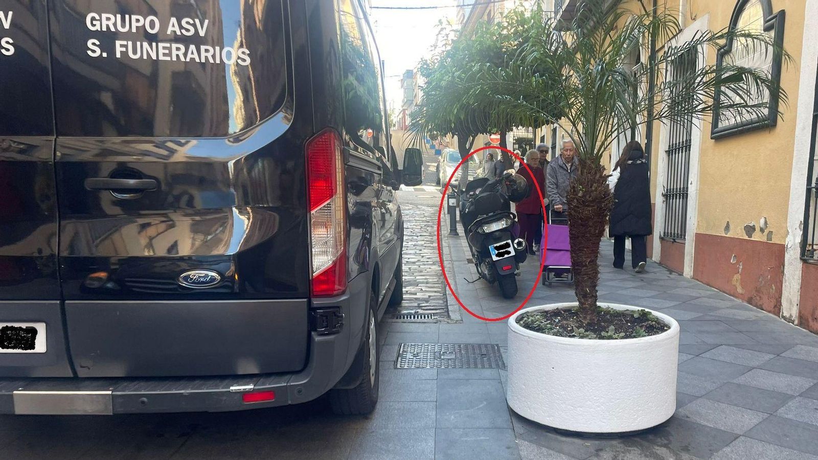 Varios peatones sortean la moto de Antonio Gallardo, aparcada sobre la acera frente al Edificio Escuela, en febrero de este año.