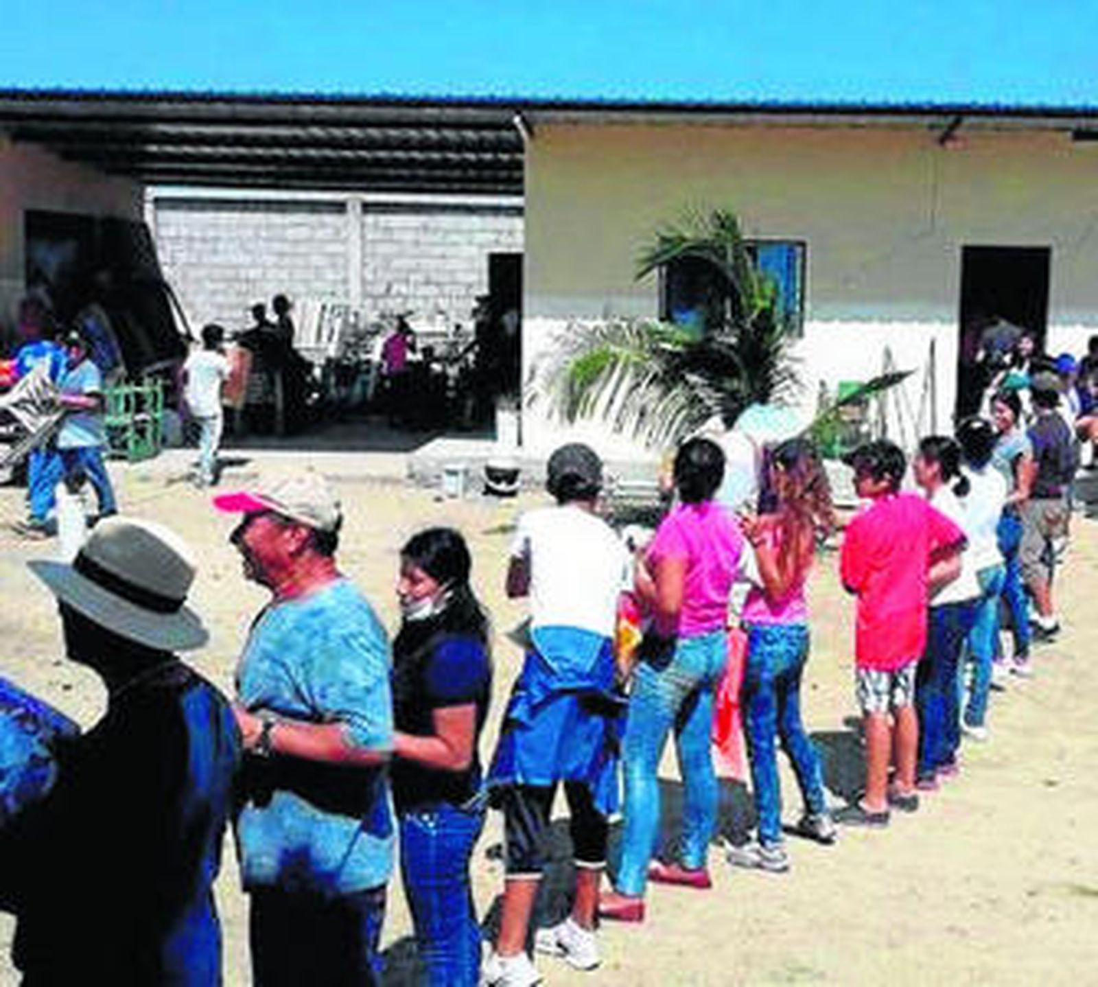 Feligreses de Drouet forman una cadena para cargar provisiones.