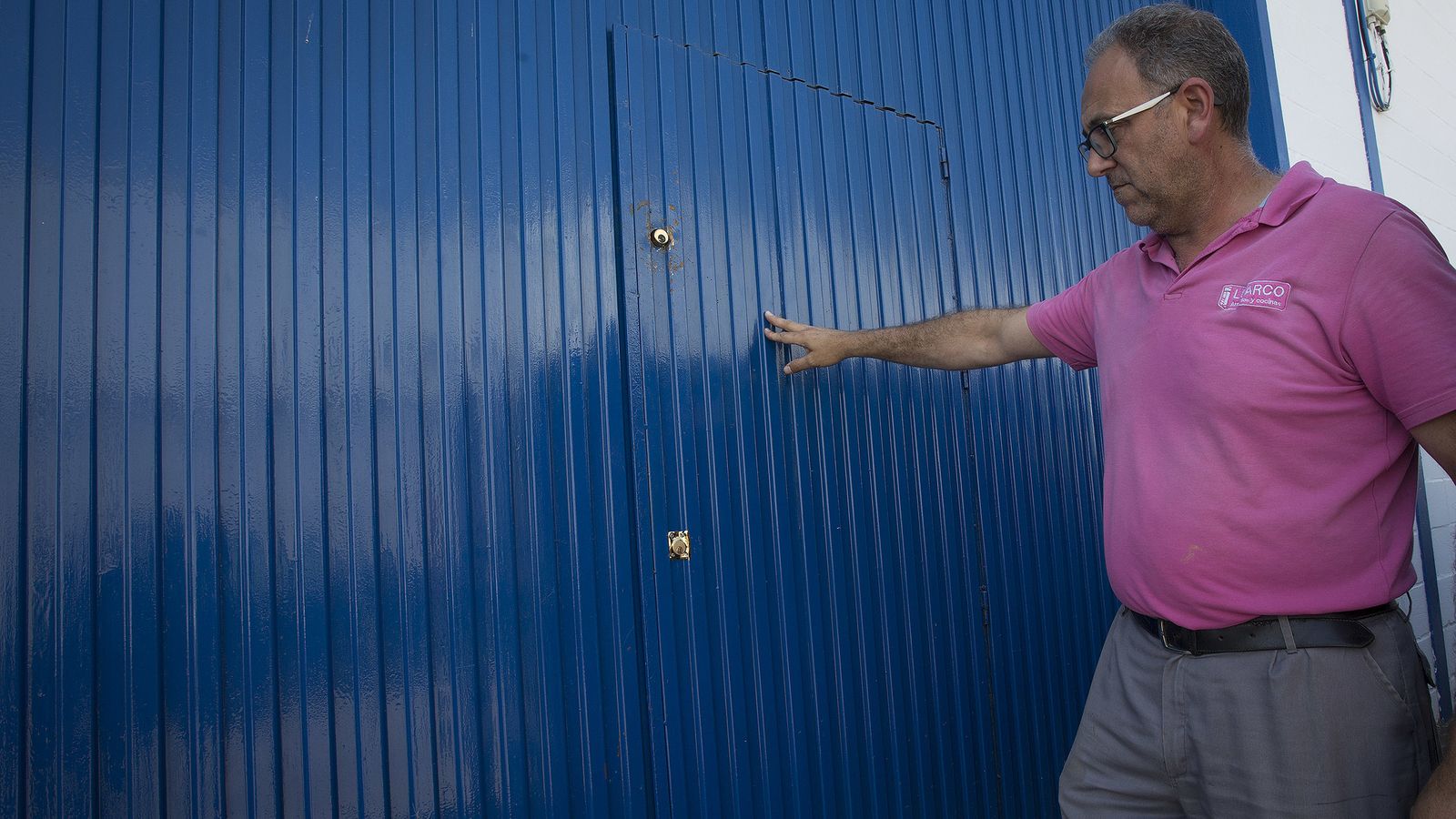 Luis Gómez muestra la puerta por la que entraron los ladrones