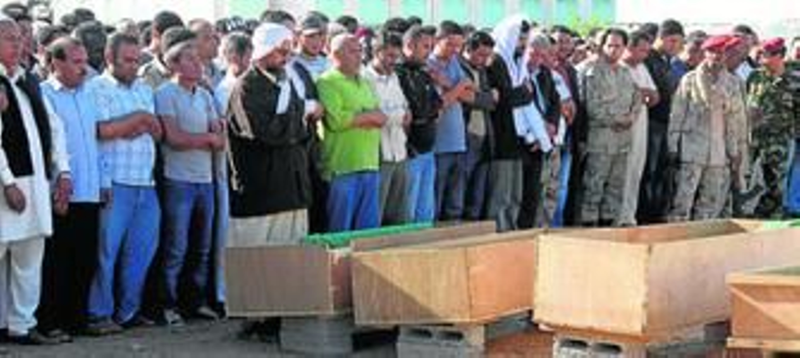 Varios libios rezan ante los ataúdes de algunas víctimas de un bombardeo de la OTAN sobre centros estratégicos de Trípoli.