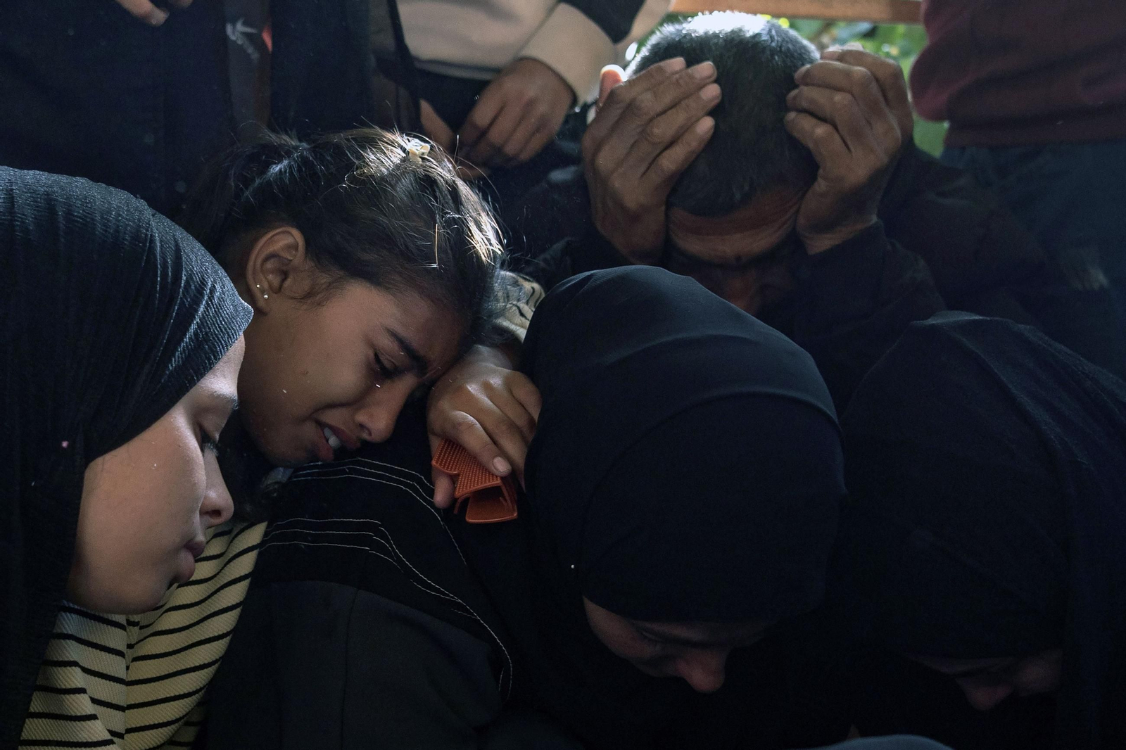 Varios palestinos lloran por sus familiares fallecidos en Jan Yunis.