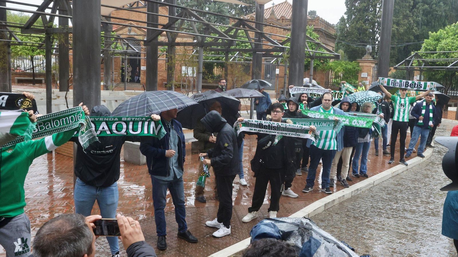 Aficionados del Betis cantan el himno al paso de la comitiva.