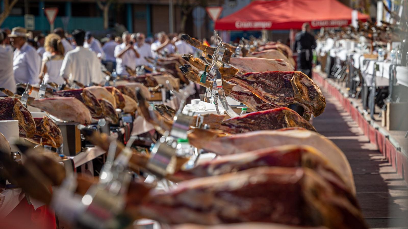 Hilera de patas de jamón, listas para cortar en la Feria Solidaria de Cortadores celebrada en San Fernando.