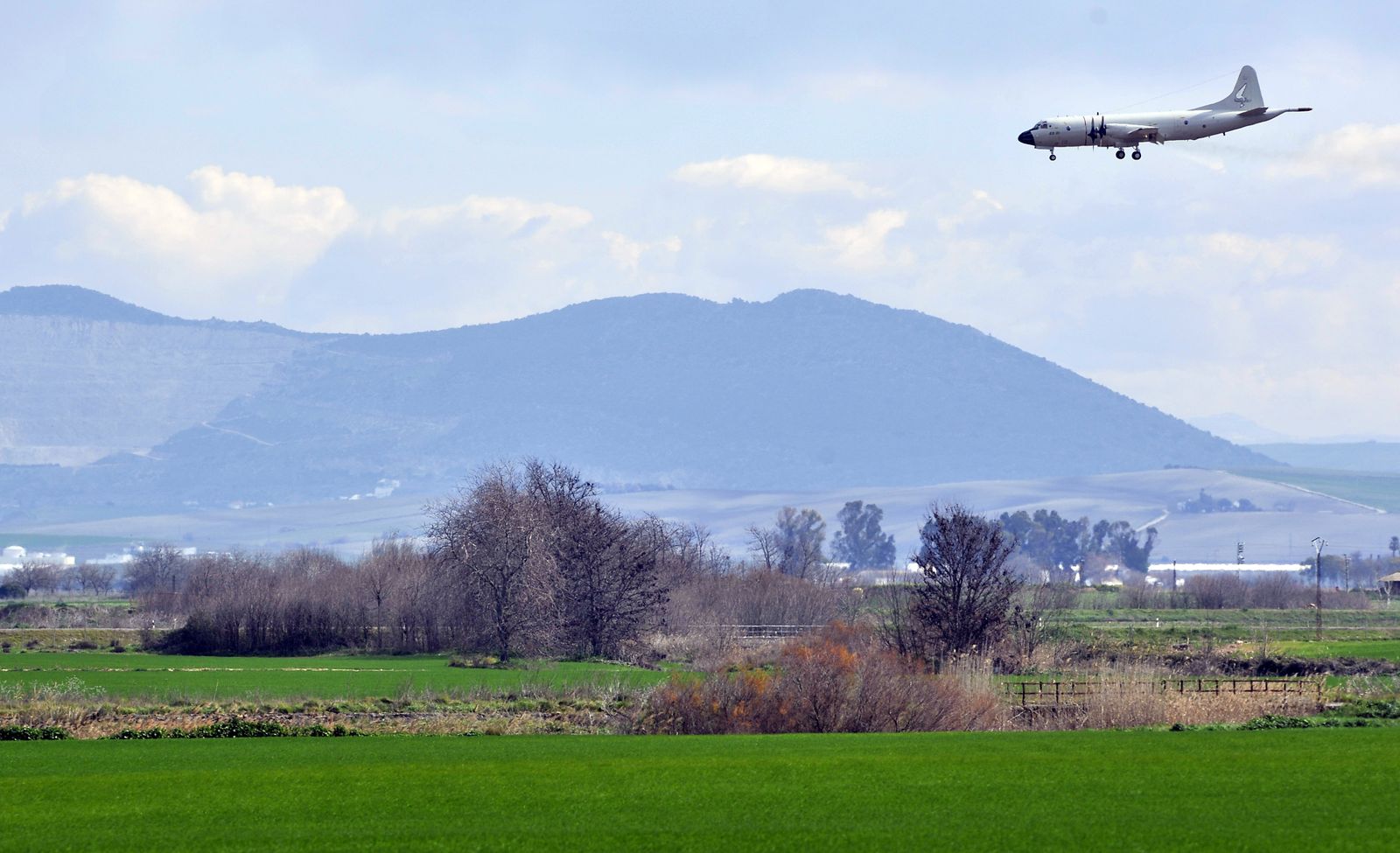 Un avión se aproxima a la base de  Morón, con la Sierra  de  Esparteros  al fondo.
