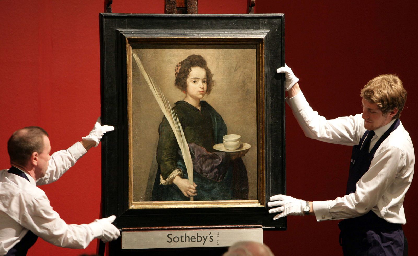 Dos operarios de la casa Sotheby's sostienen el cuadro de Velázquez el 4 de julio de 2007 tras ser adquirido por la Fundación Focus.