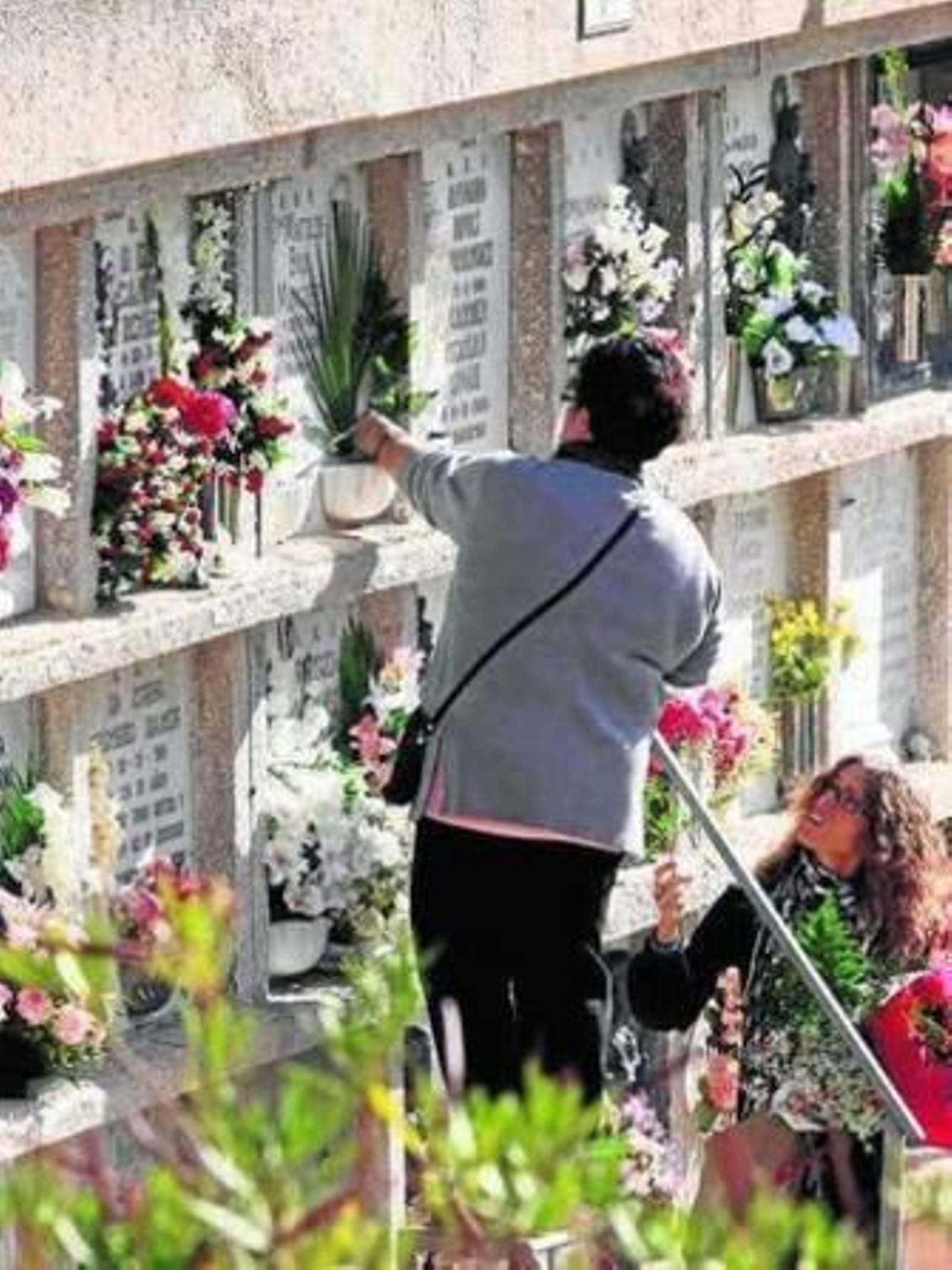 Una mujer coloca flores en el cementerio de San Gabriel. Una mujer coloca flores en el cementerio de San Gabriel.