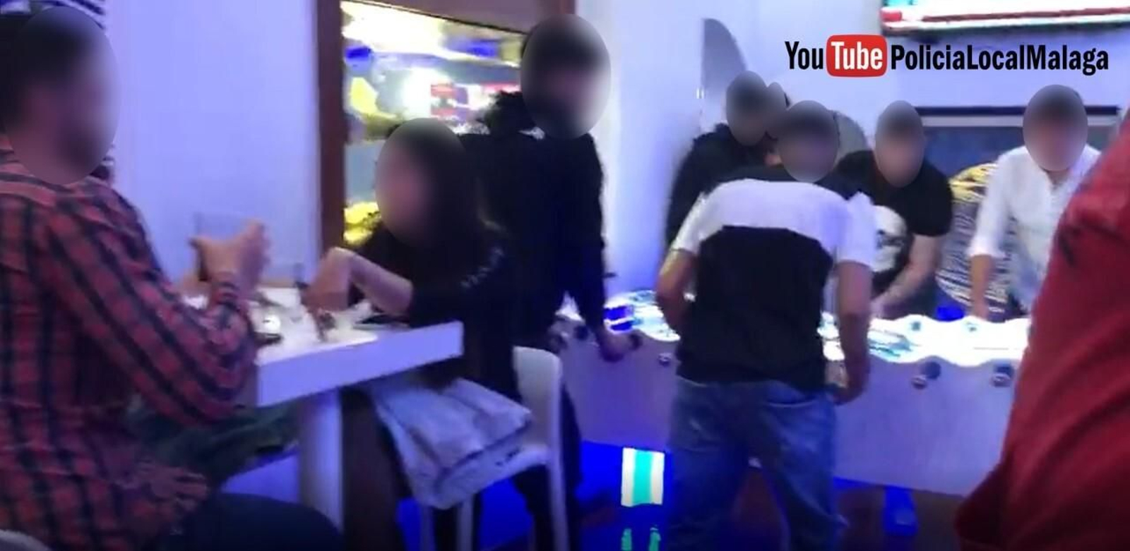 Jóvenes sin mascarilla jugando al futbolín sorprendidos por la Policía