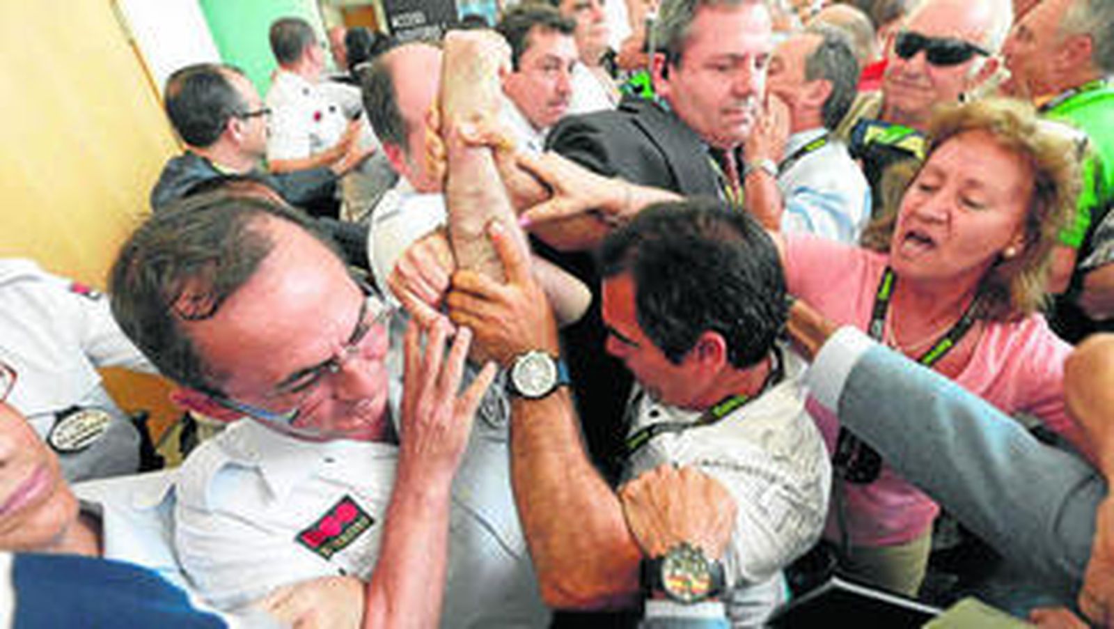 Un grupo de accionistas forcejea para intentar acceder a la junta cuando el aforo estaba completo.