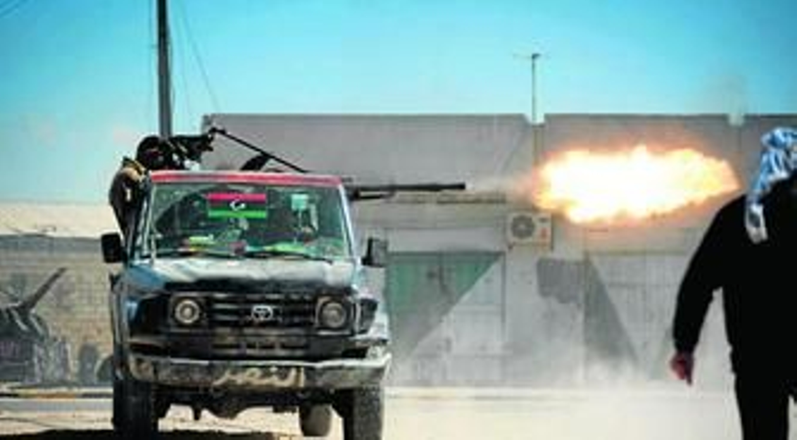 Un rebelde dispara desde una camioneta en los violentos combates que están teniendo lugar en Misrata.
