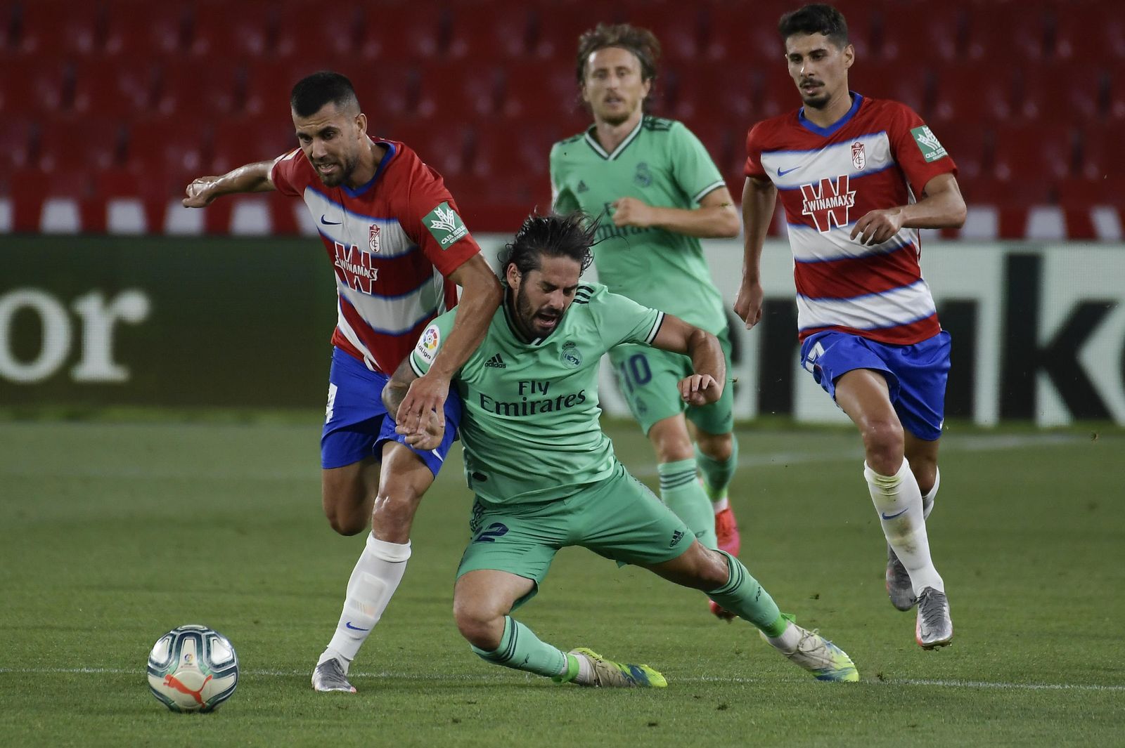Fede Vico le gana la posición a Isco que cae en el césped de Los Cármenes.