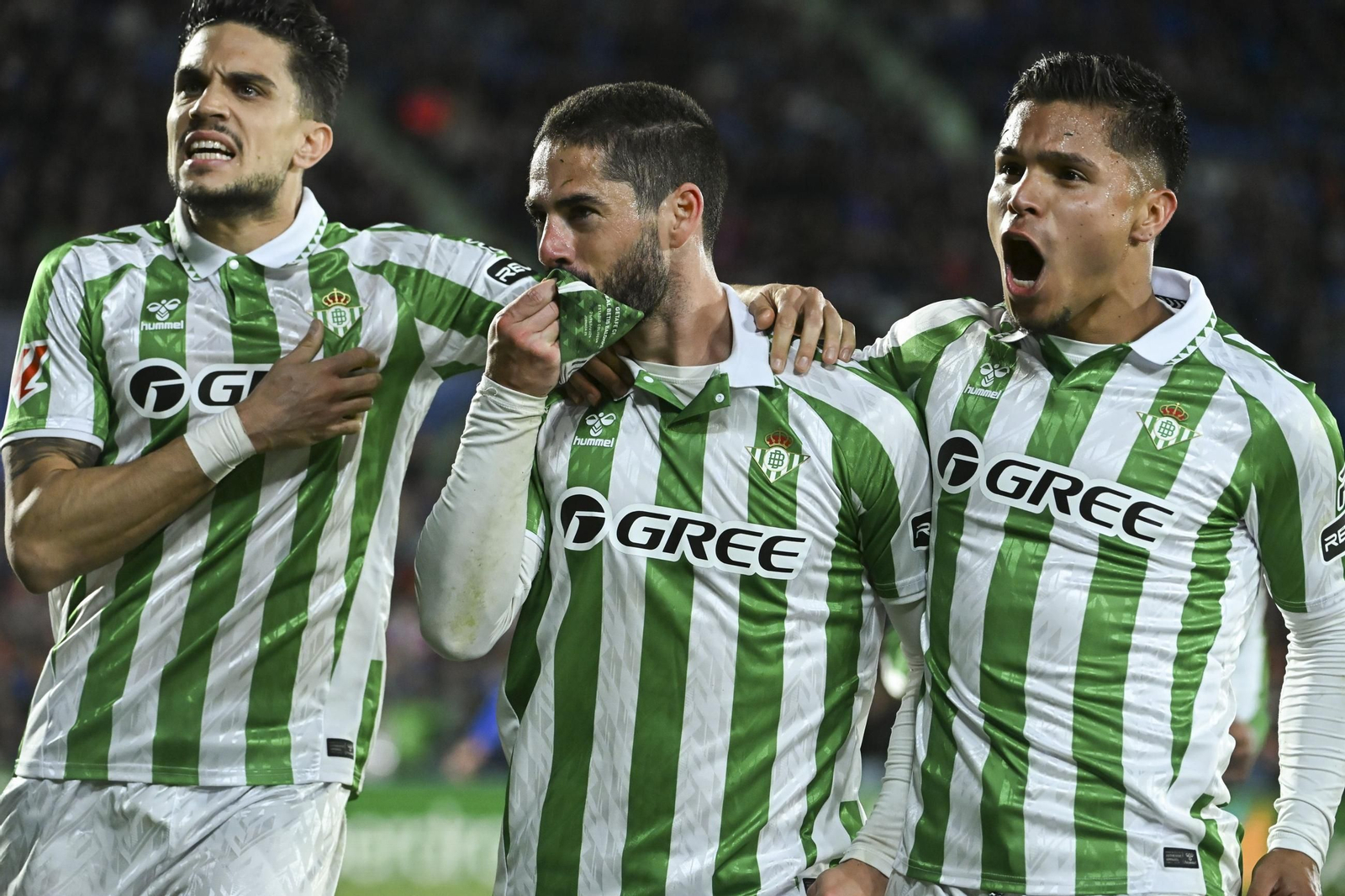 Isco besa el brazalete de capitán del Betis ante Bartra y el Cucho Hernández. Isco besa el brazalete de capitán del Betis ante Bartra y el Cucho Hernández.