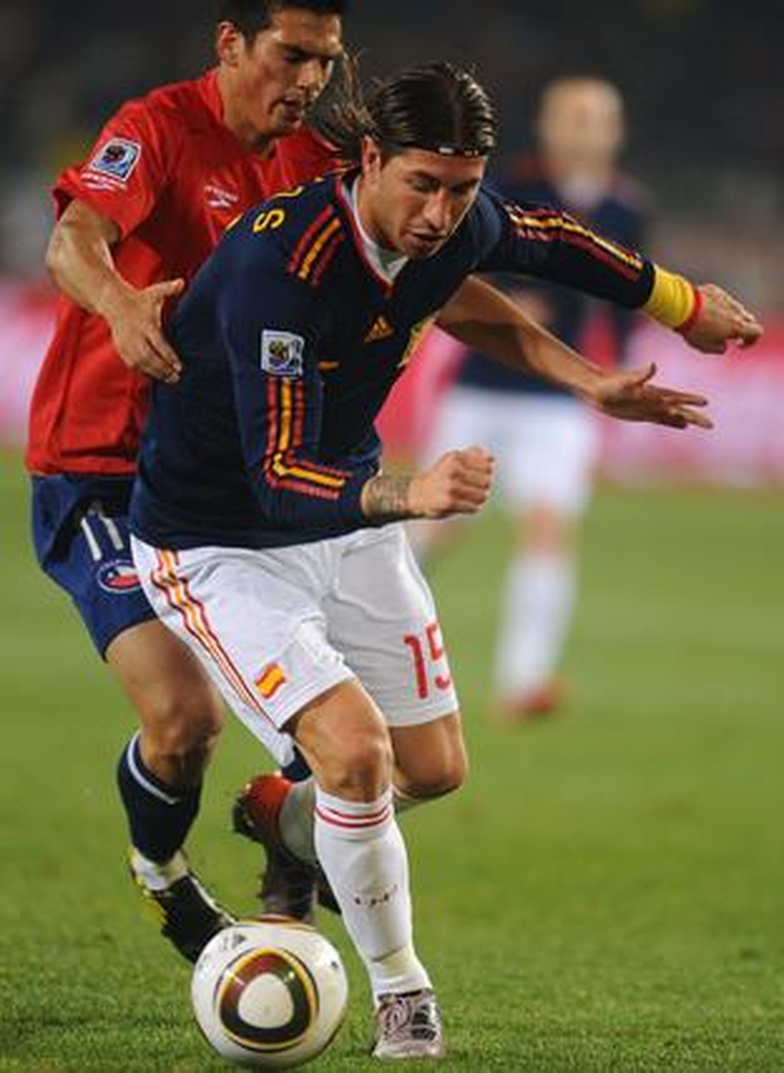 Ramos protege la pelota ante la presión de Mark González. / Reportaje gráfico: EFE, Reuters, AFP.