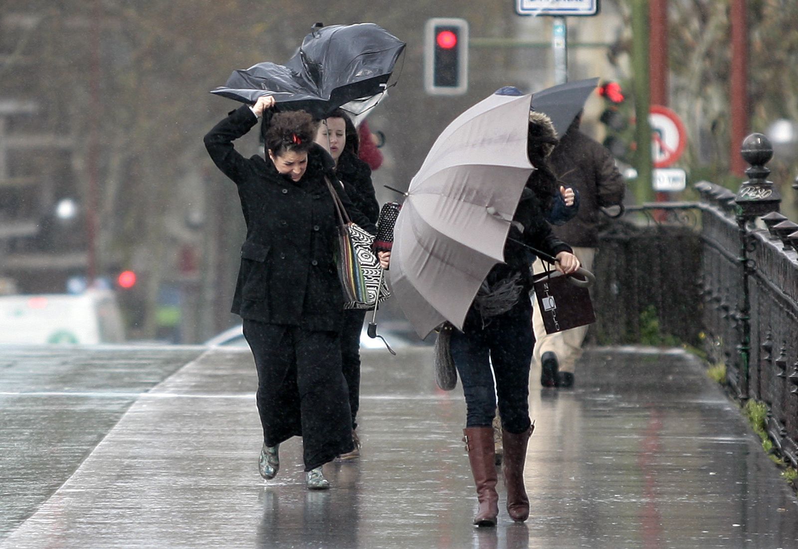 Varias personas sufren una fuerte racha de viento.