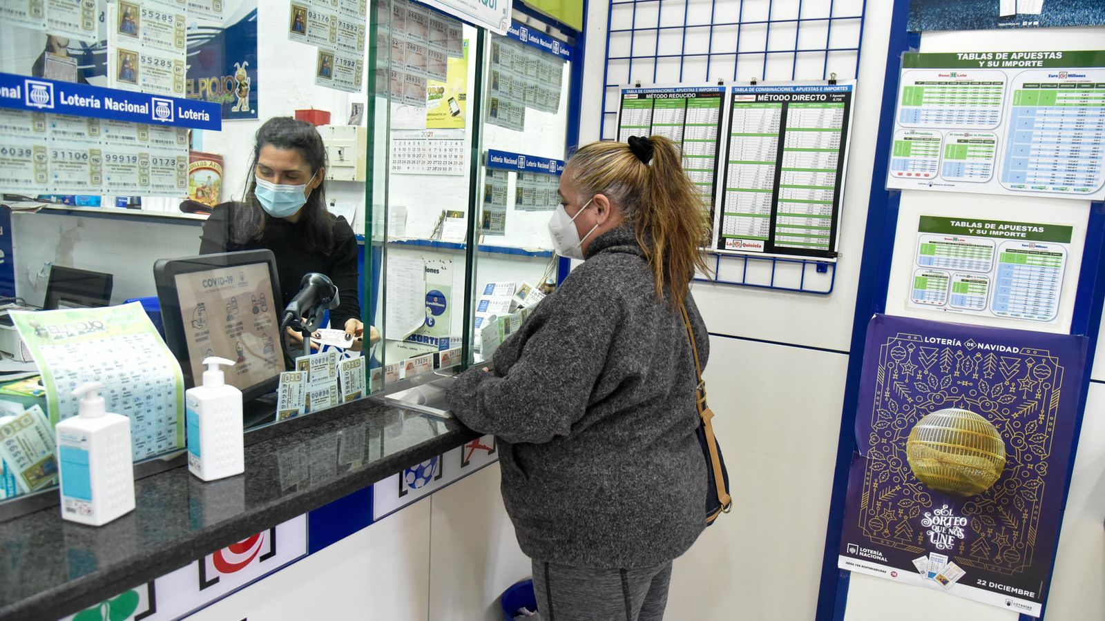 Una mujer compra lotería.