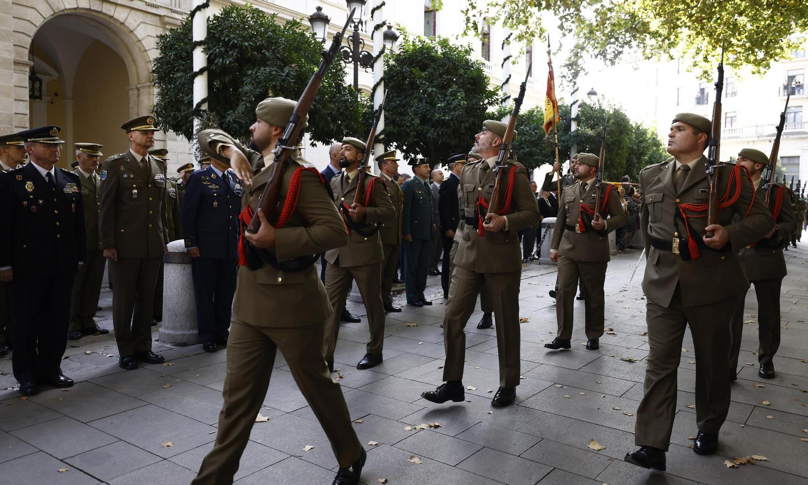 El izado de bandera y desfile militar por el centro de Sevilla, en imágenes