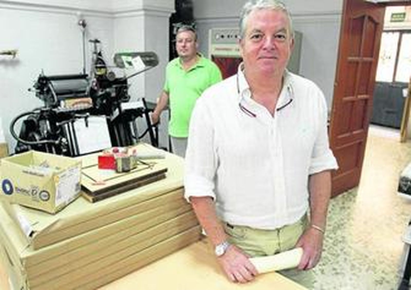José Manuel Muñoz Pérez, en su imprenta del Muro de los Navarros. Detrás, su hermano Luis junto a una Heidelberg.