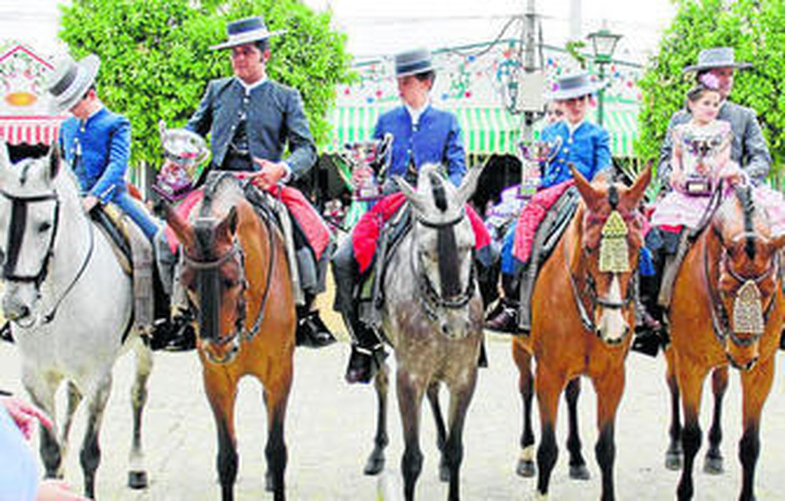 Los caballistas premiados con su trofeo en la mano.