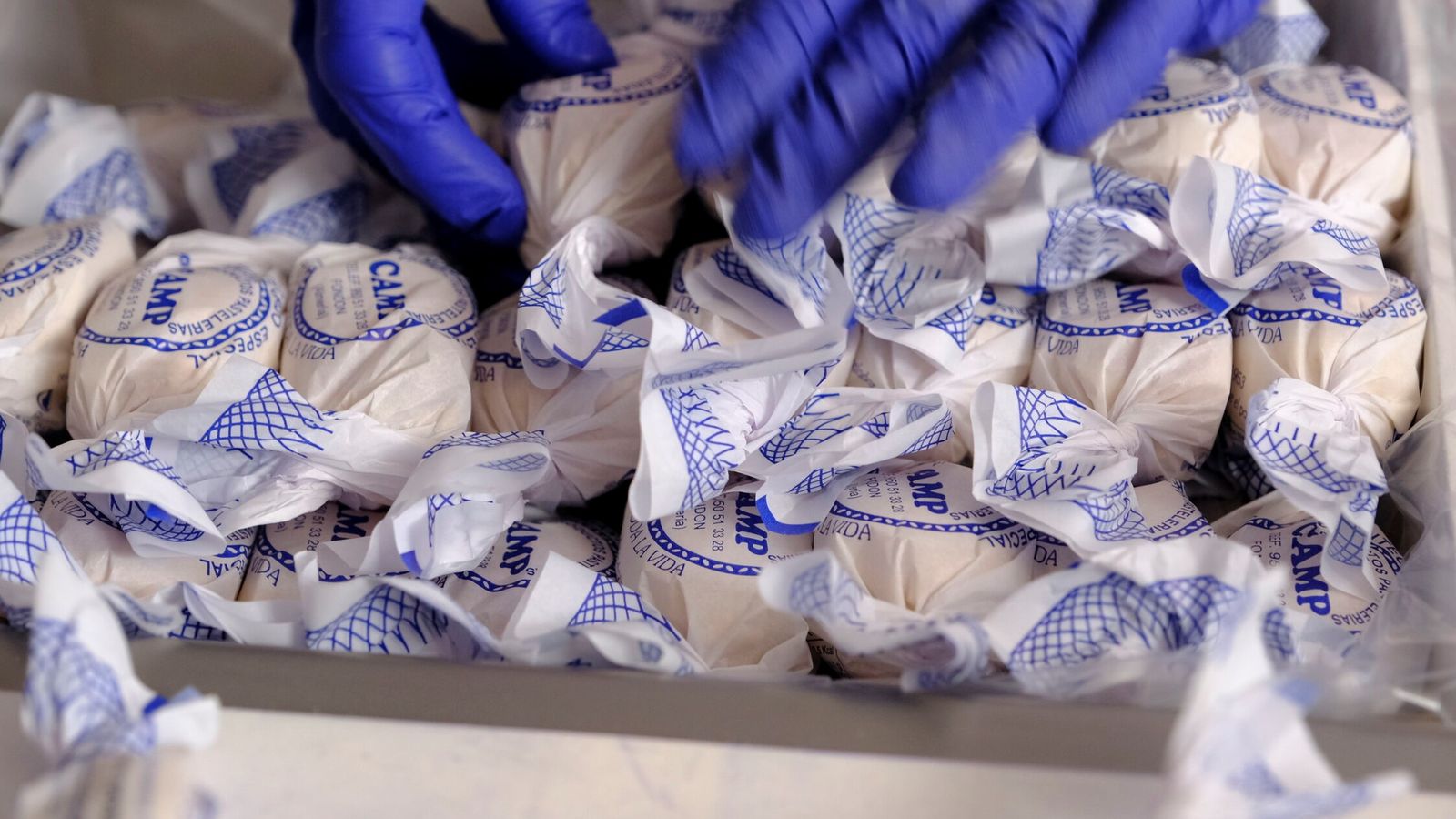 Un dependiente coloca un importante números de mantecados en una caja.