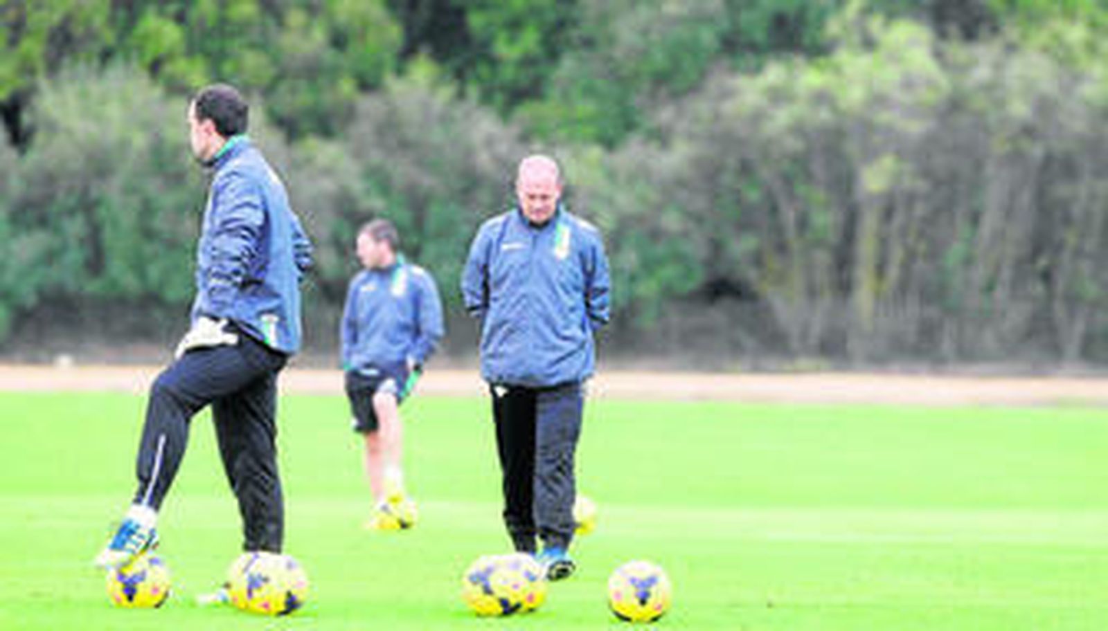 Pepe Mel, con gesto de preocupación, durante un entrenamiento, con Relaño en primer plano y David Gómez al fondo.