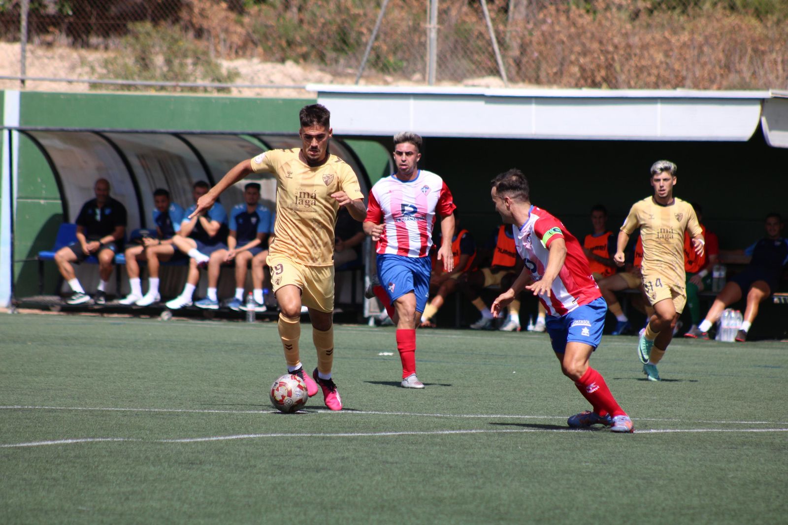 Linares defiende al malaguista Chupe, autor de un hat-trick, durante una acción del choque de la primera jornada del campeonato.