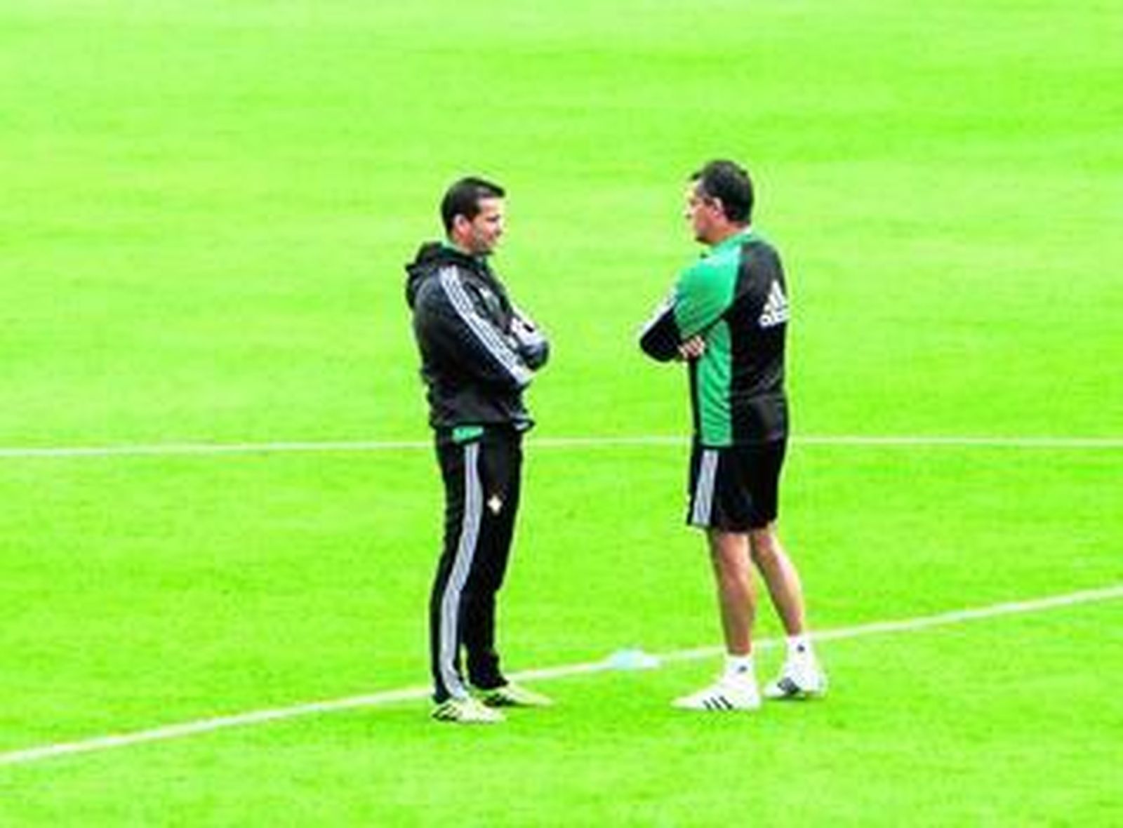 El entrenador, Juan Merino, dialoga con Alexis Trujillo, durante el entrenamiento de ayer.