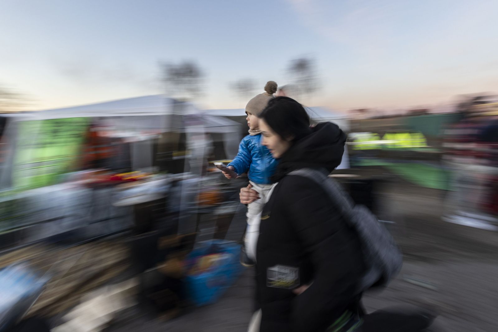 Una mujer sale de Ucrania con un niño en brazos.