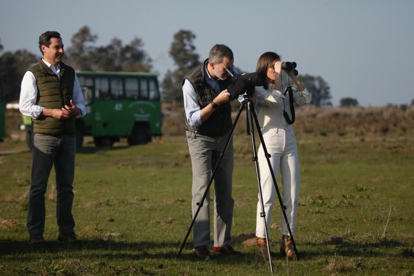 Don Felipe y Doña Letizia observan la fauna de Doñana a través de unos prismáticos acompañados por Juanma Moreno.