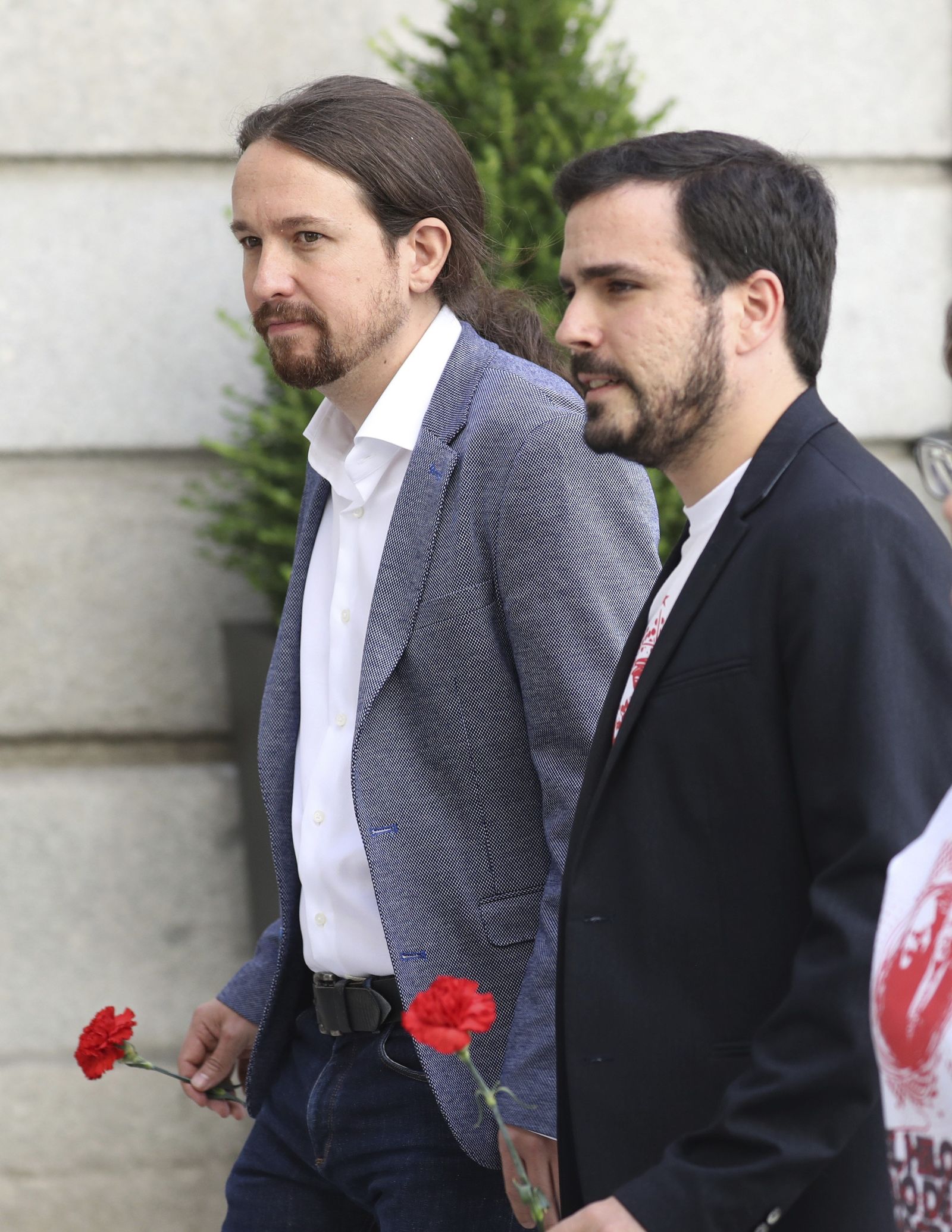 Pablo Iglesias y Alberto Garzón con claveles rojos.