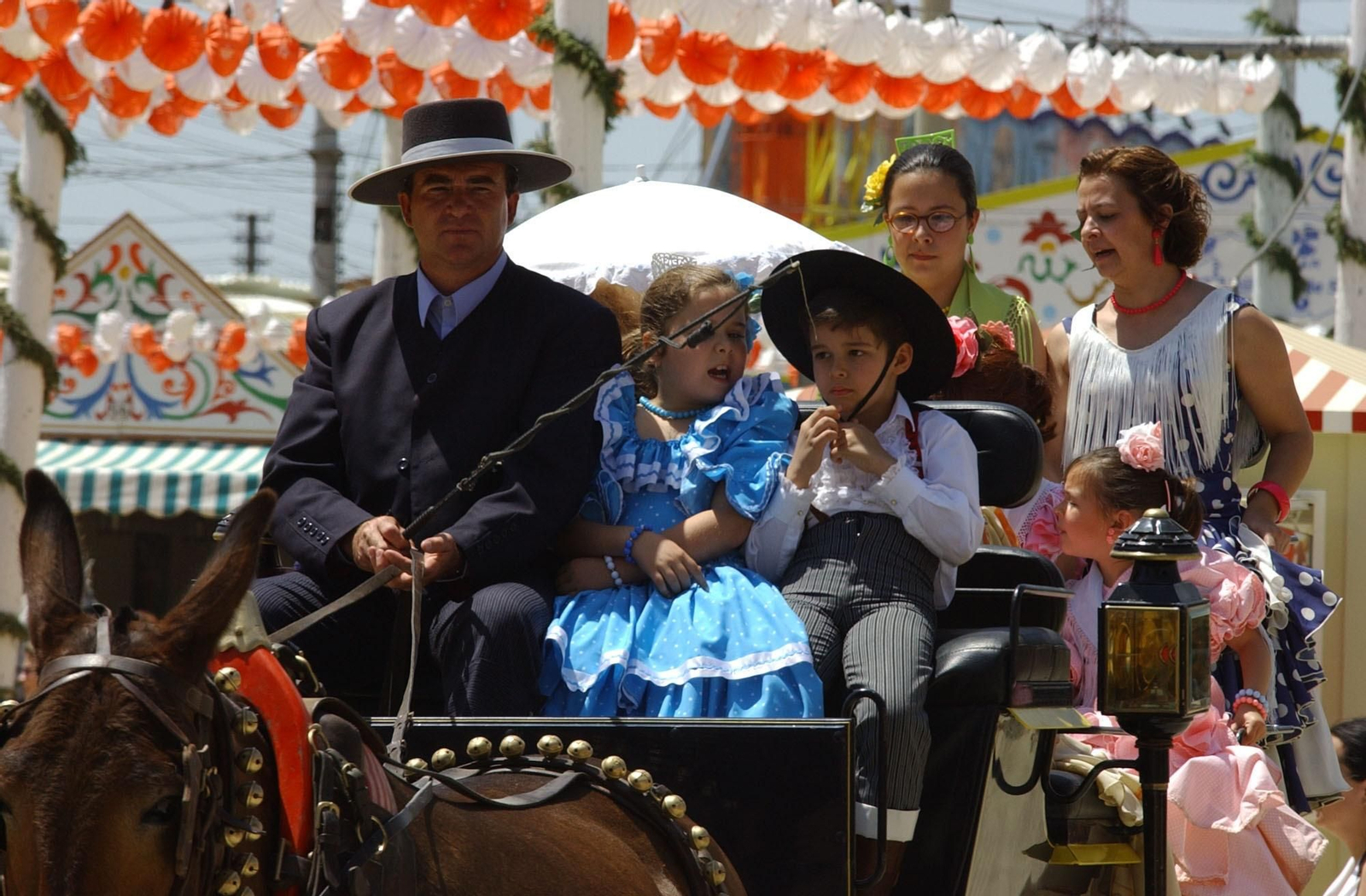 Una familia disfruta, en coche de caballo, de la Feria de Abril.