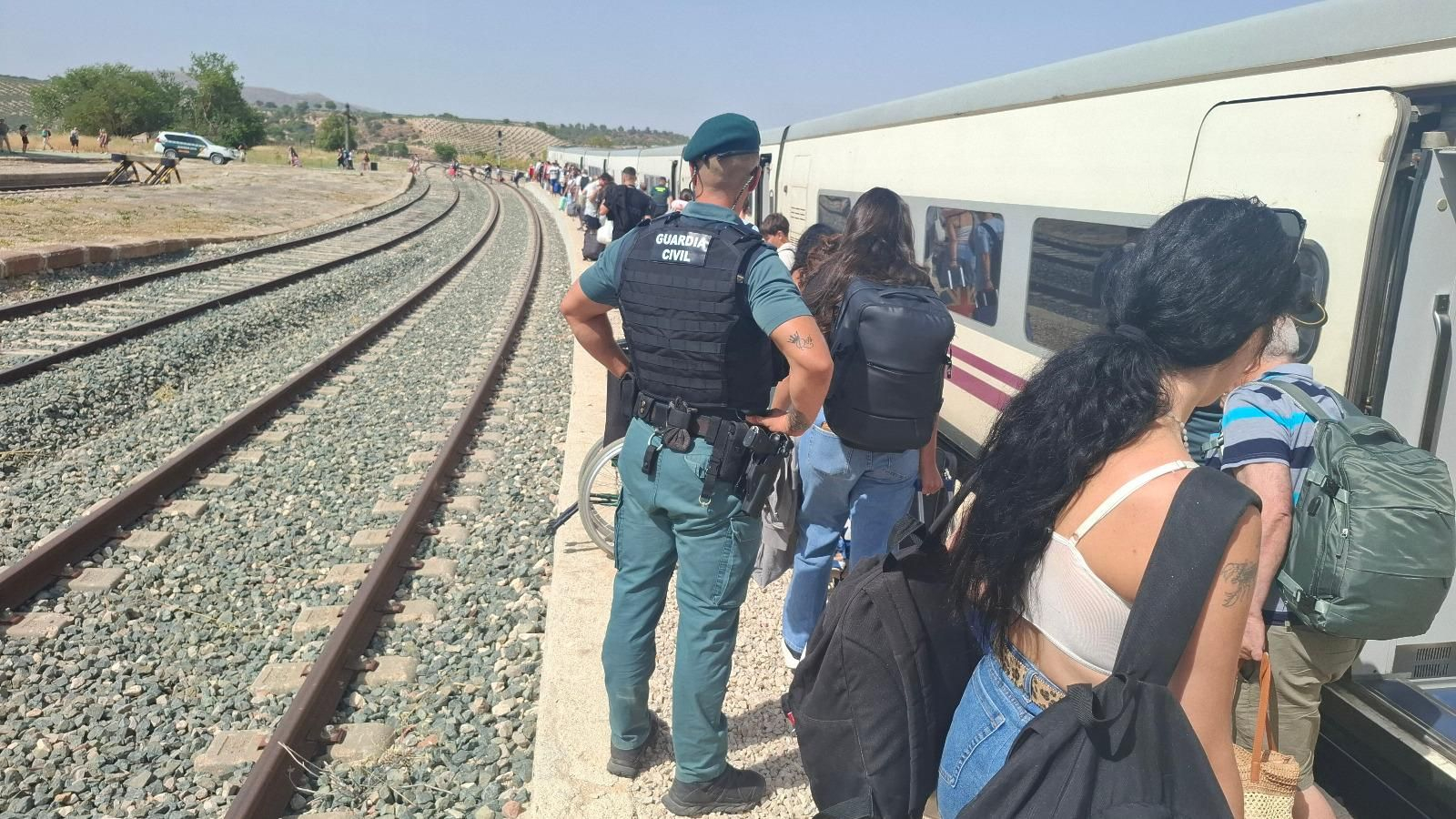 Los viajeros del tren abandonan los vagones camino de ls autobuses en la estación de Alamedilla-Guadahortuna