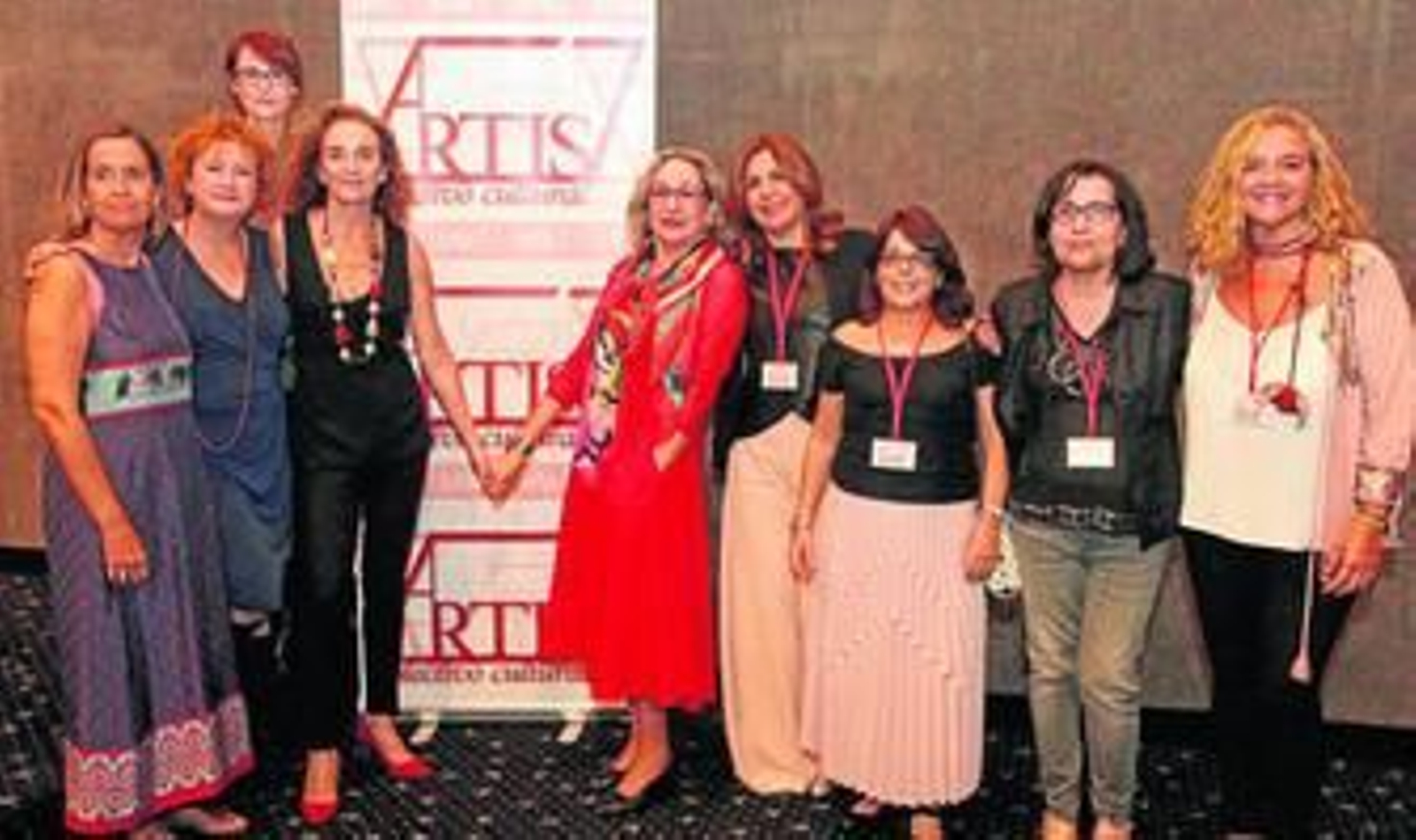Consuelo Trujillo -de negro a la izquierda- y Luisa Gavasa, ambas de la mano, junto al cartel de Artis 7 en el Palacio de Congresos de La Línea.