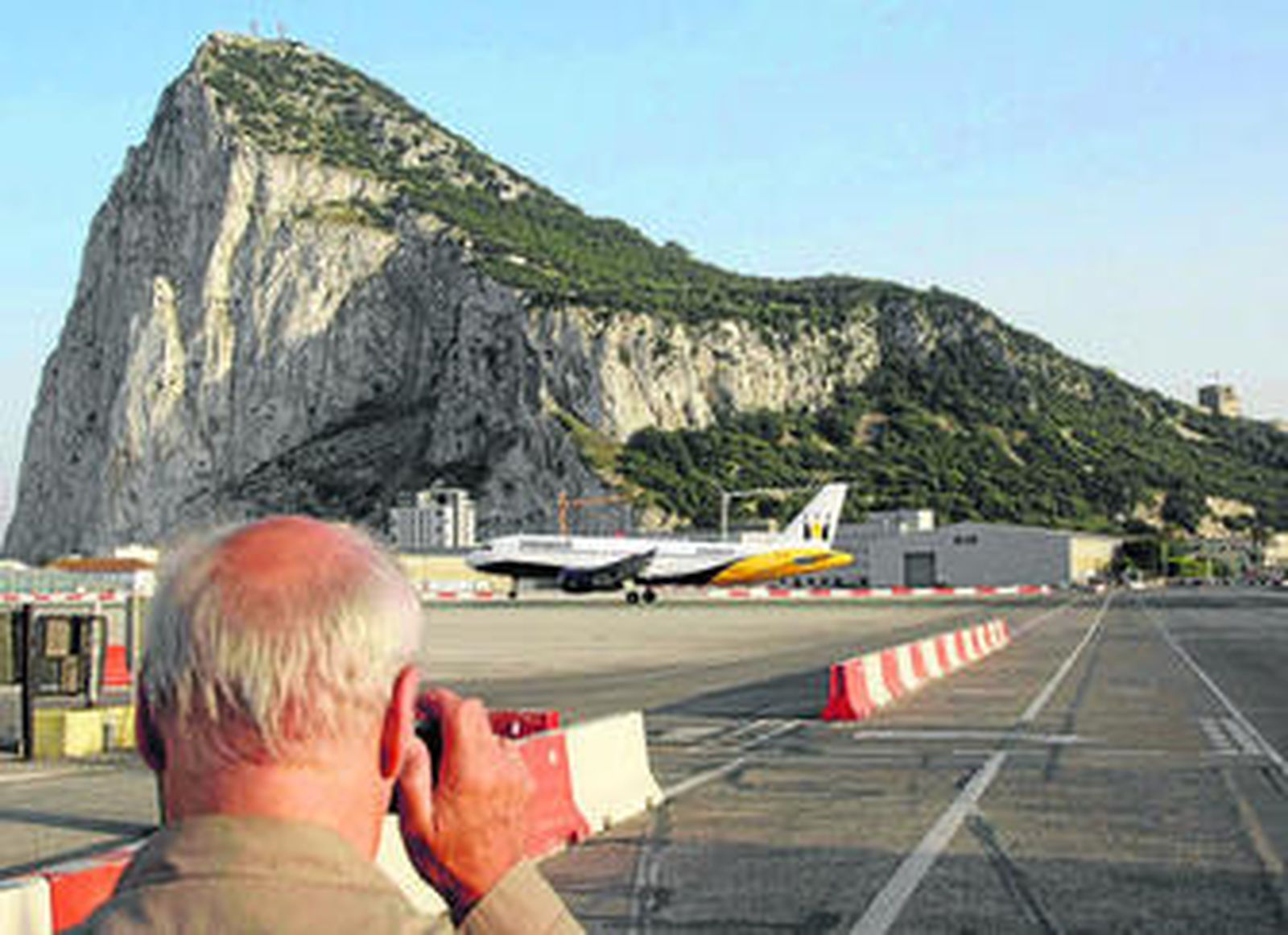 Un hombre fotografía un avión operando, ayer, en el aeropuerto de la colonia británica de Gibraltar.