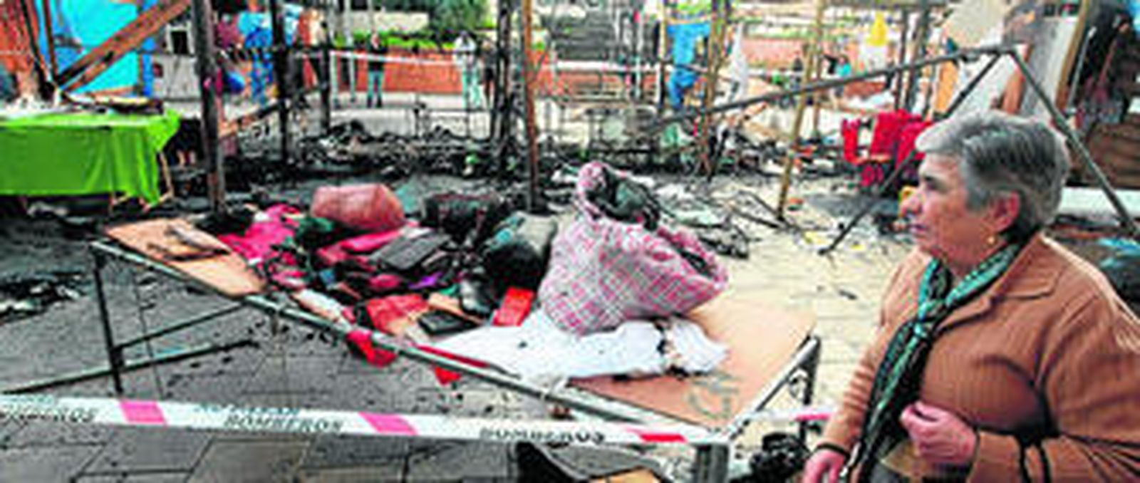 Vecinos observan el efecto del fuego en el mercadillo.