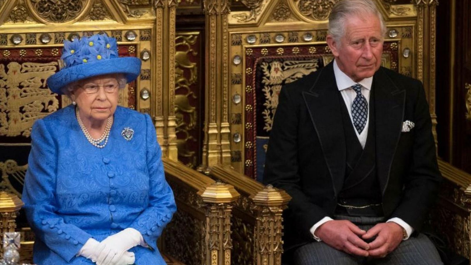 Carlos de Inglaterra sentado junto a la soberana inglesa.