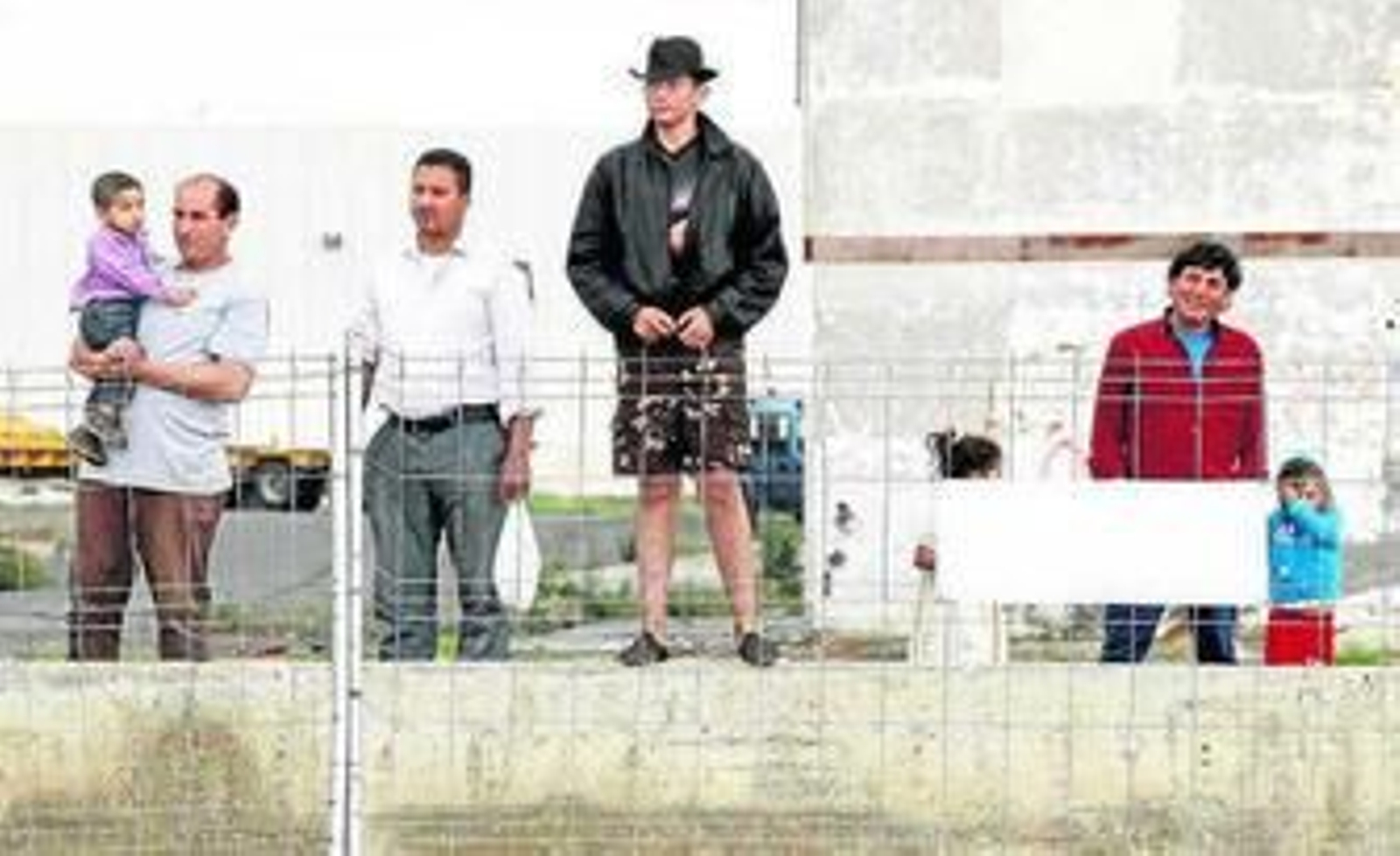 Un grupo de habitantes de El Puche asiste al derribo de viviendas.