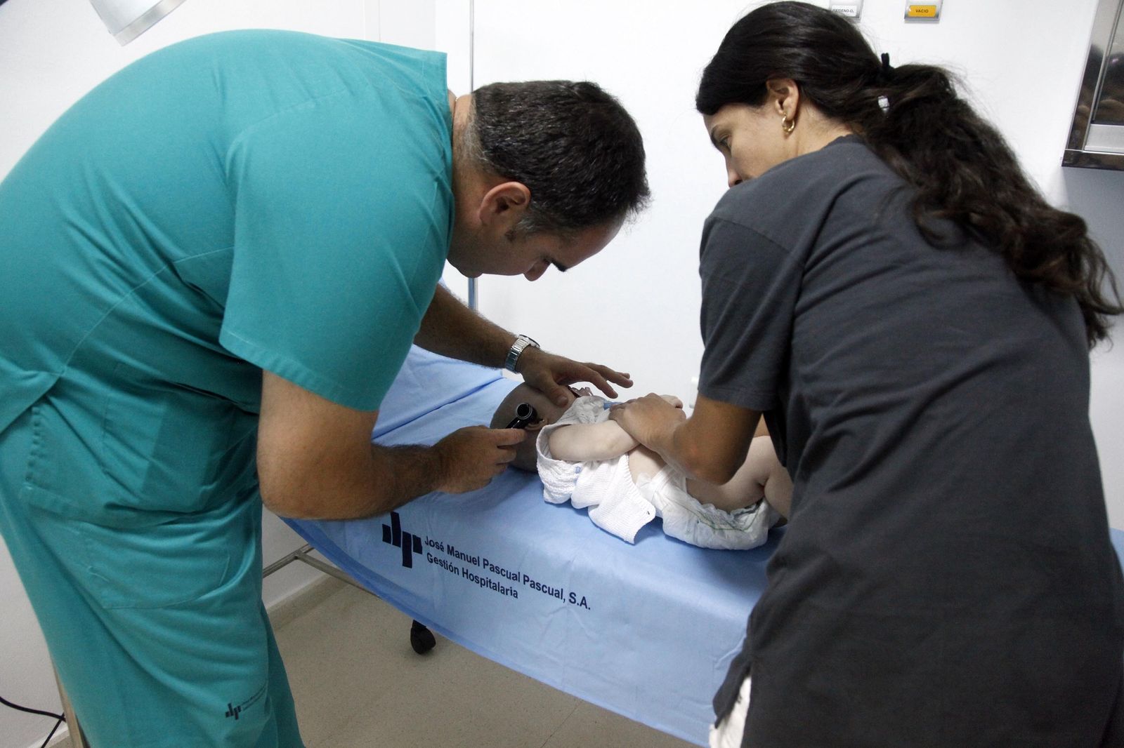 Dos sanitarios atienden a un bebé.