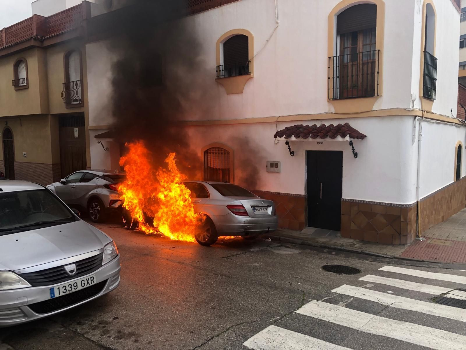 Un 'Mercedes' arde en la calle Pinzón de Algeciras, este lunes por la mañana.